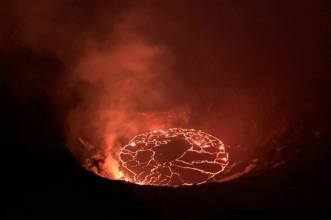 夜間火山口內發光的熔岩湖，煙霧升騰