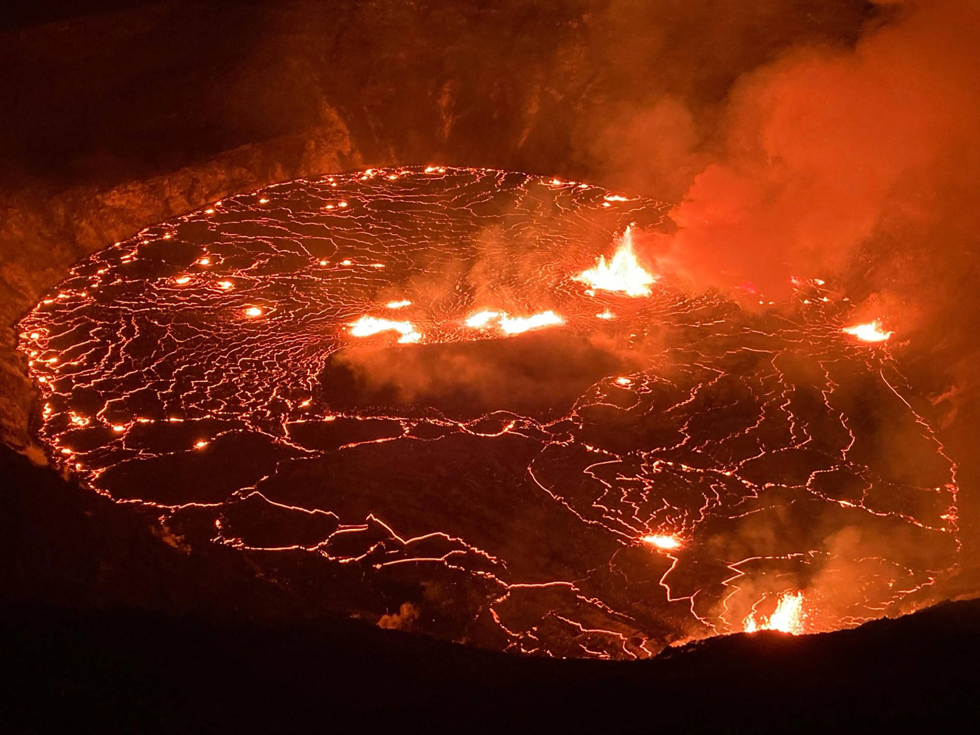 夜晚的火山口，發光的熔岩在表面流動。