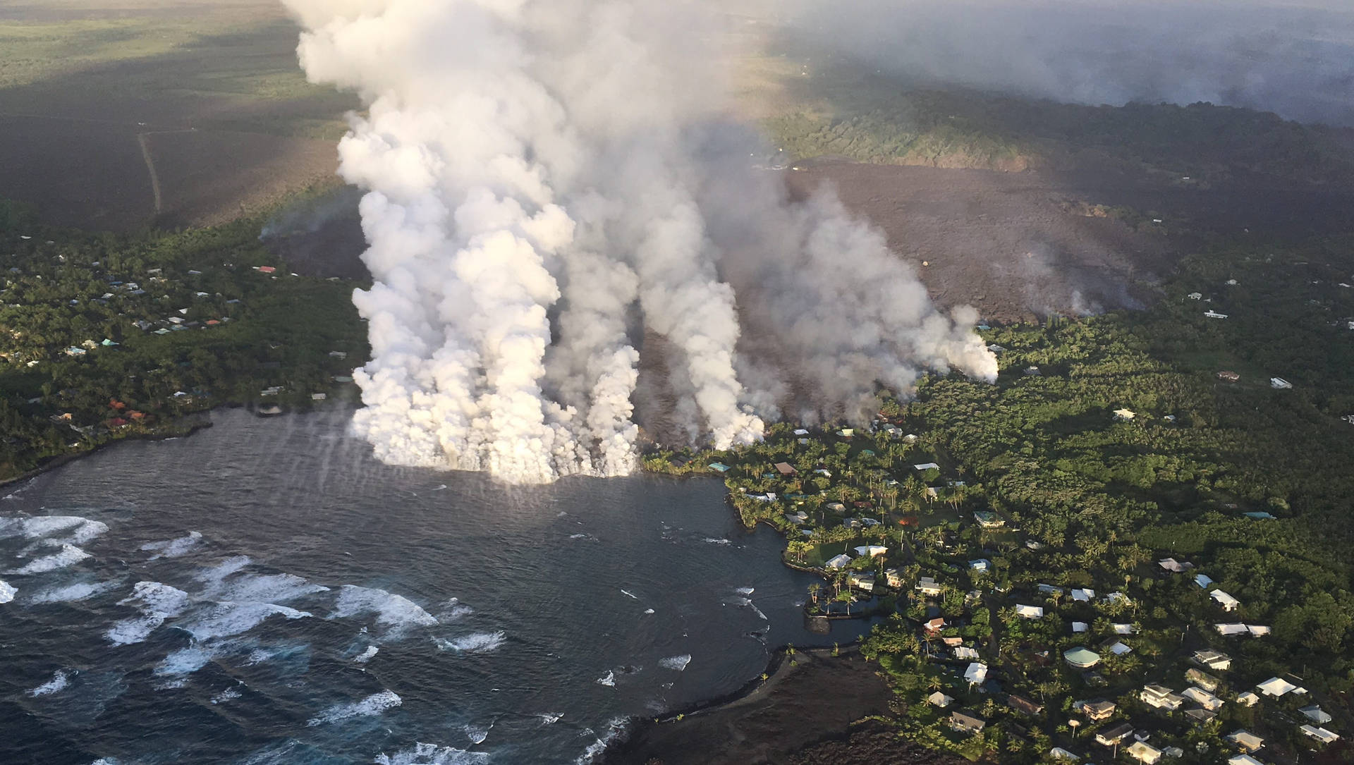 火山爆發，濃煙籠罩沿海城鎮與海洋。