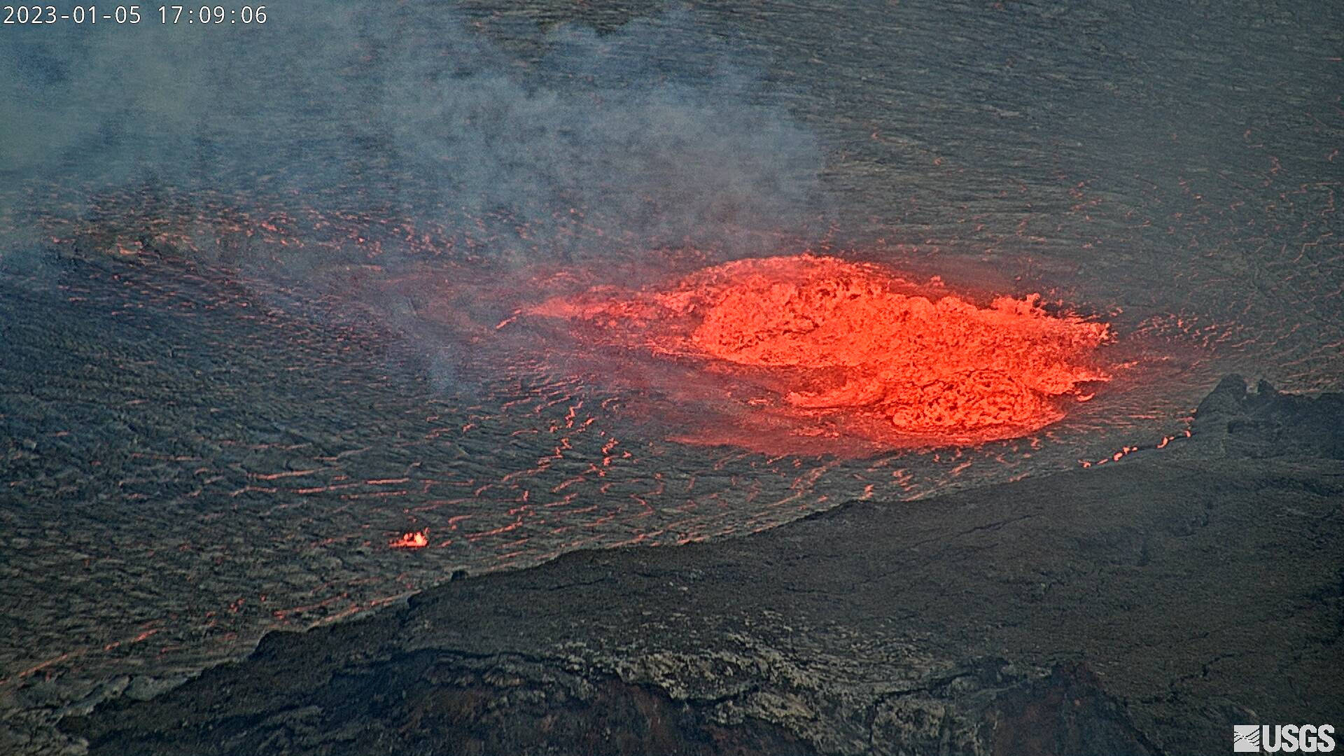 火山爆發，明亮的紅色熔岩流過黑色的火山岩。