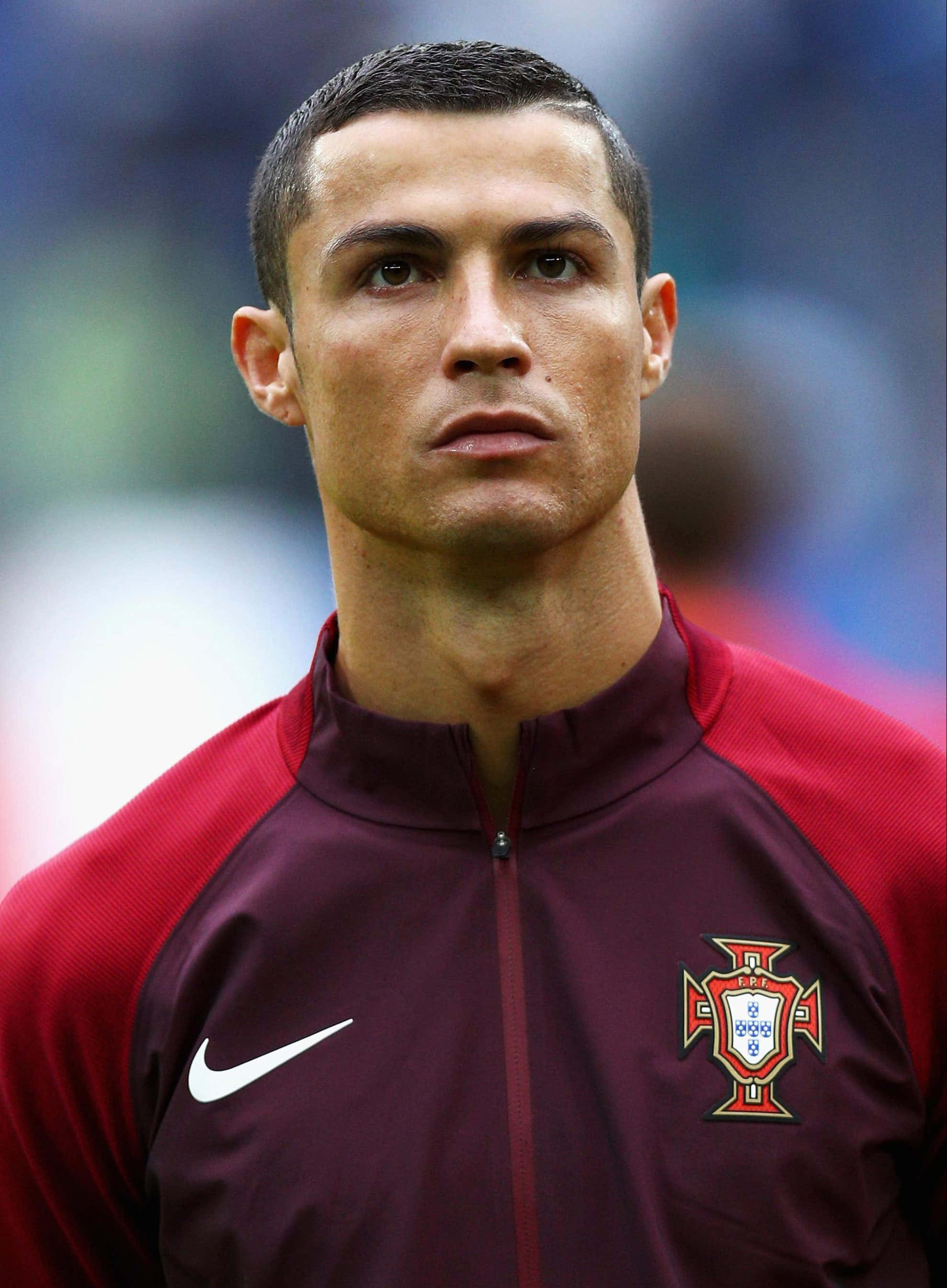 Ronaldo 桌布 壁紙 — 基斯坦奴·朗拿度嘅近距離肖像，身穿栗色同紅色嘅葡萄牙訓練外套，表情專注。