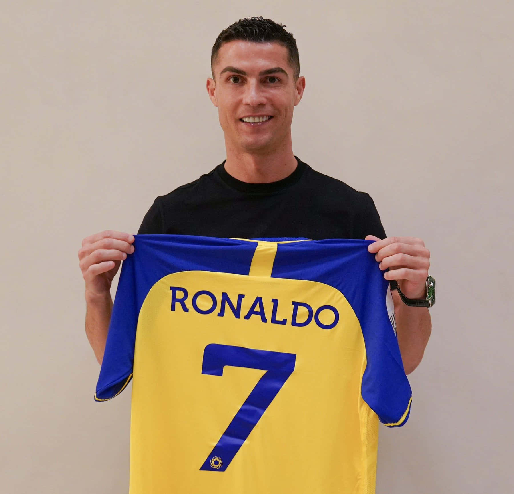 Cristiano Ronaldo 桌布 壁紙 — 基斯坦奴·朗拿度微笑著舉起一件印有他名字和7號的黃藍色足球球衣。