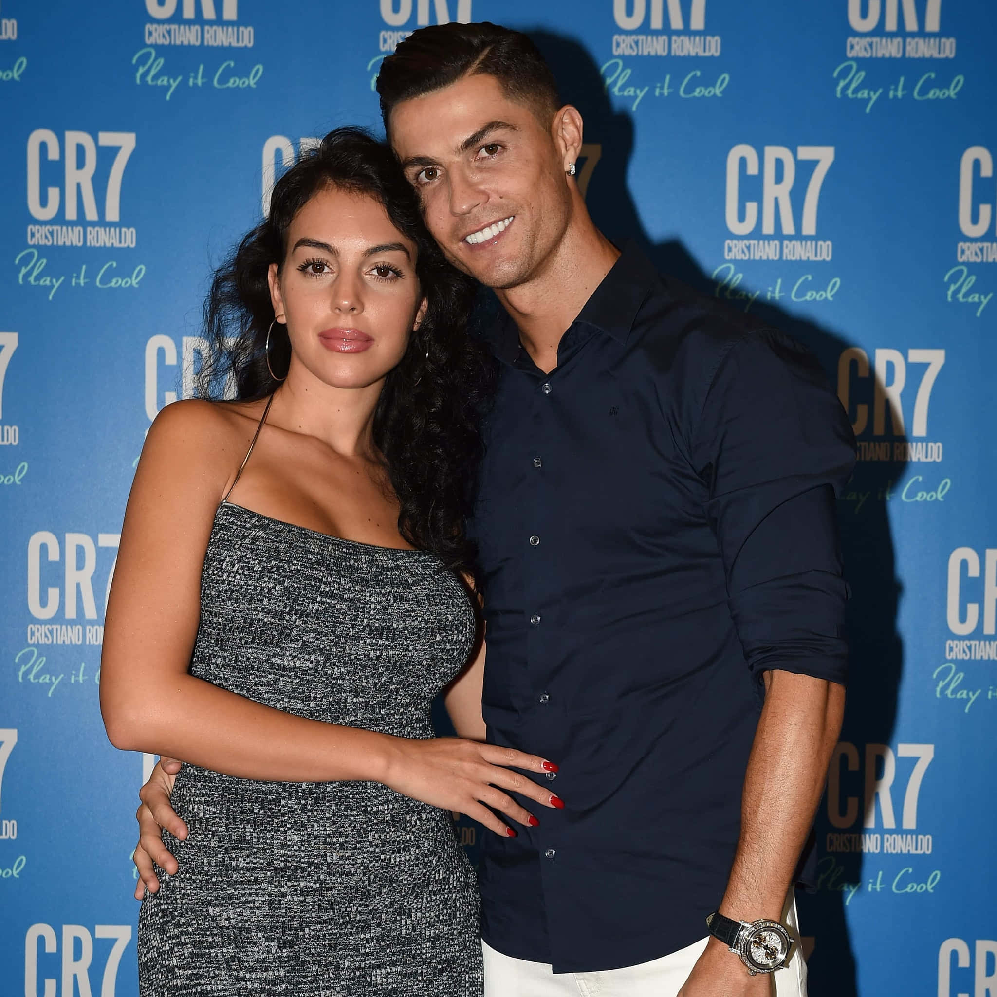 Cristiano Ronaldo 桌布 壁紙 — 基斯坦奴·朗拿度與佐治娜·洛迪古斯在一個CR7品牌活動中，以藍色背景一起擺姿勢。