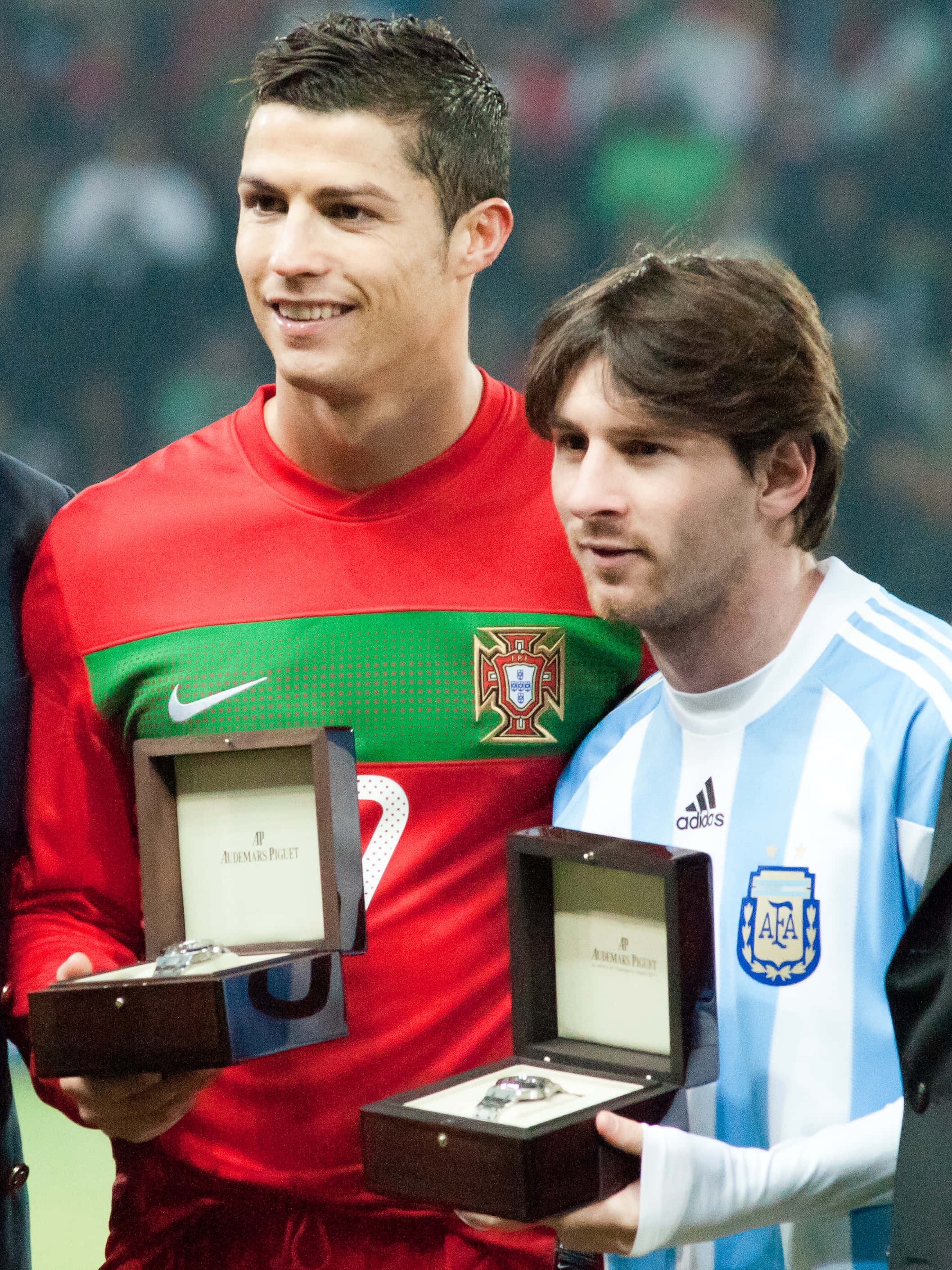 Cristiano Ronaldo 桌布 壁紙 — 基斯坦奴·朗拿度與利安奴·美斯並肩站立，身穿國家隊球衣，手持打開的木盒，內有手錶。