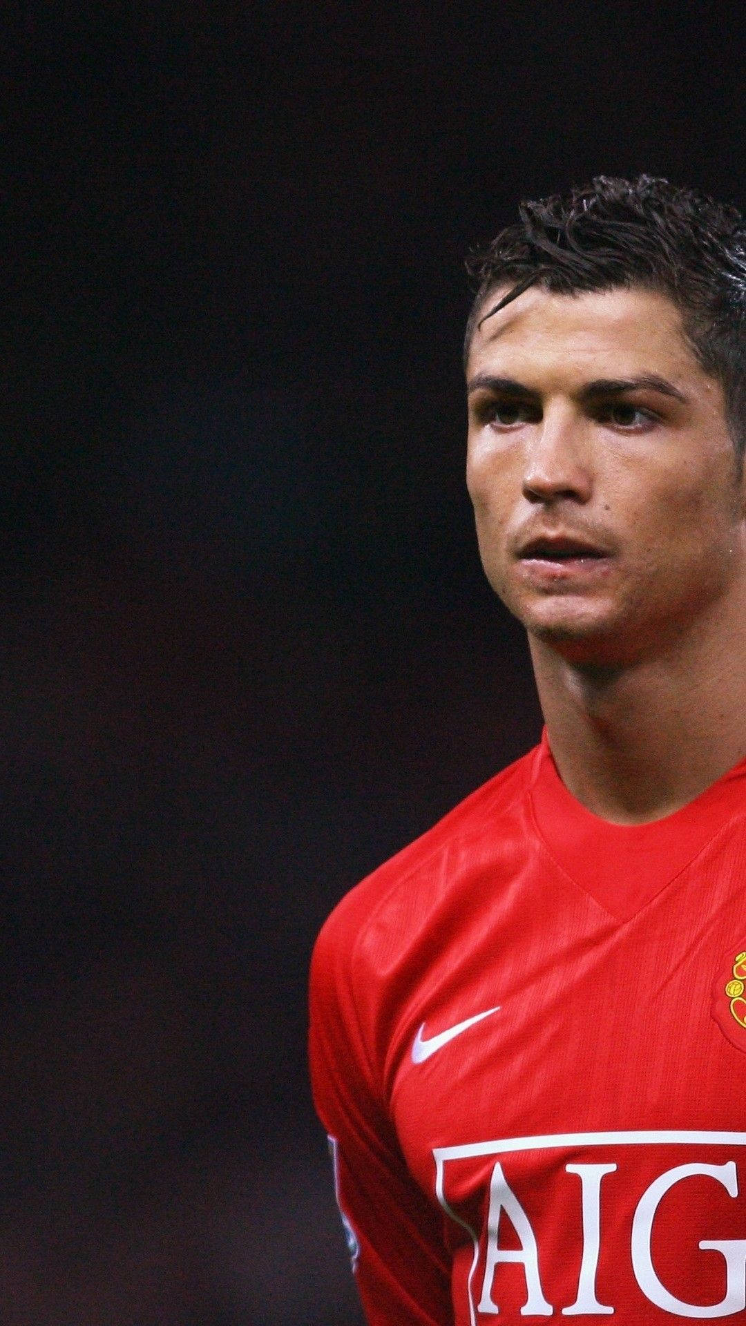 Cristiano Ronaldo 桌布 壁紙 — 基斯坦奴·朗拿度身穿紅色曼聯球衣，在黑暗模糊背景下的特寫肖像。