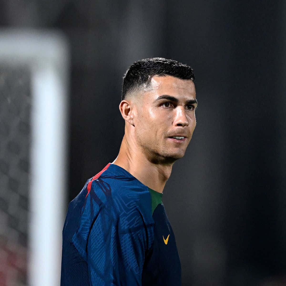 Cristiano Ronaldo 桌布 壁紙 — 基斯坦奴·朗拿度身穿藍色訓練服，在夜晚球場燈光下專注地站在足球龍門附近。