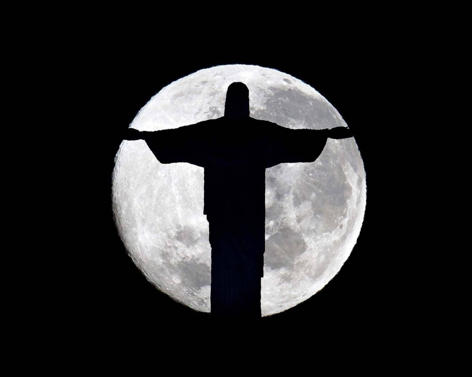 Jesus Aesthetic 桌布 壁紙 — 基督救世主雕像的剪影完美地鑲嵌在黑色天空中的巨大滿月之中。