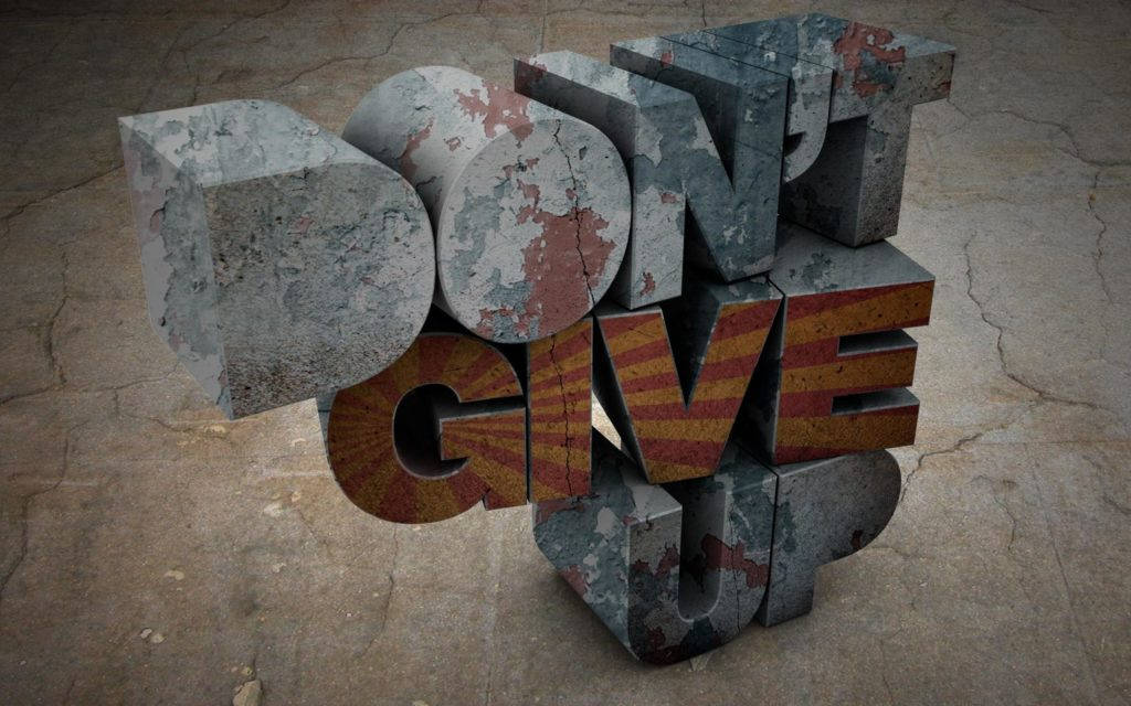 堅持不懈最佳桌面提醒背景 壁紙 — 風化的3D字母拼出「DON'T GIVE UP」，擱在裂開的混凝土上，帶有剝落的油漆和鏽蝕紋理。