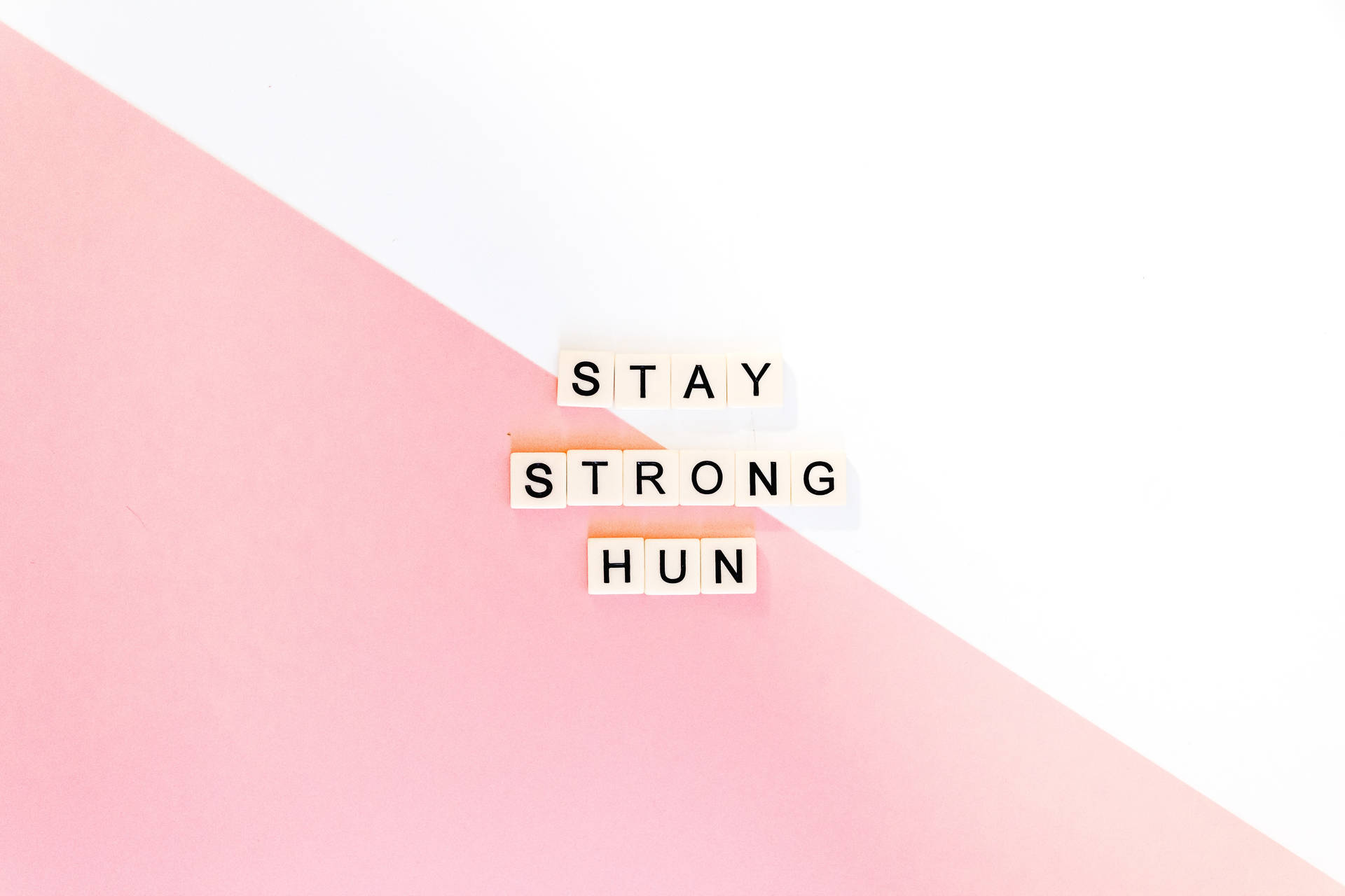 粉紅與白色背景上寫有「STAY STRONG HUN」的勵志文字方塊。