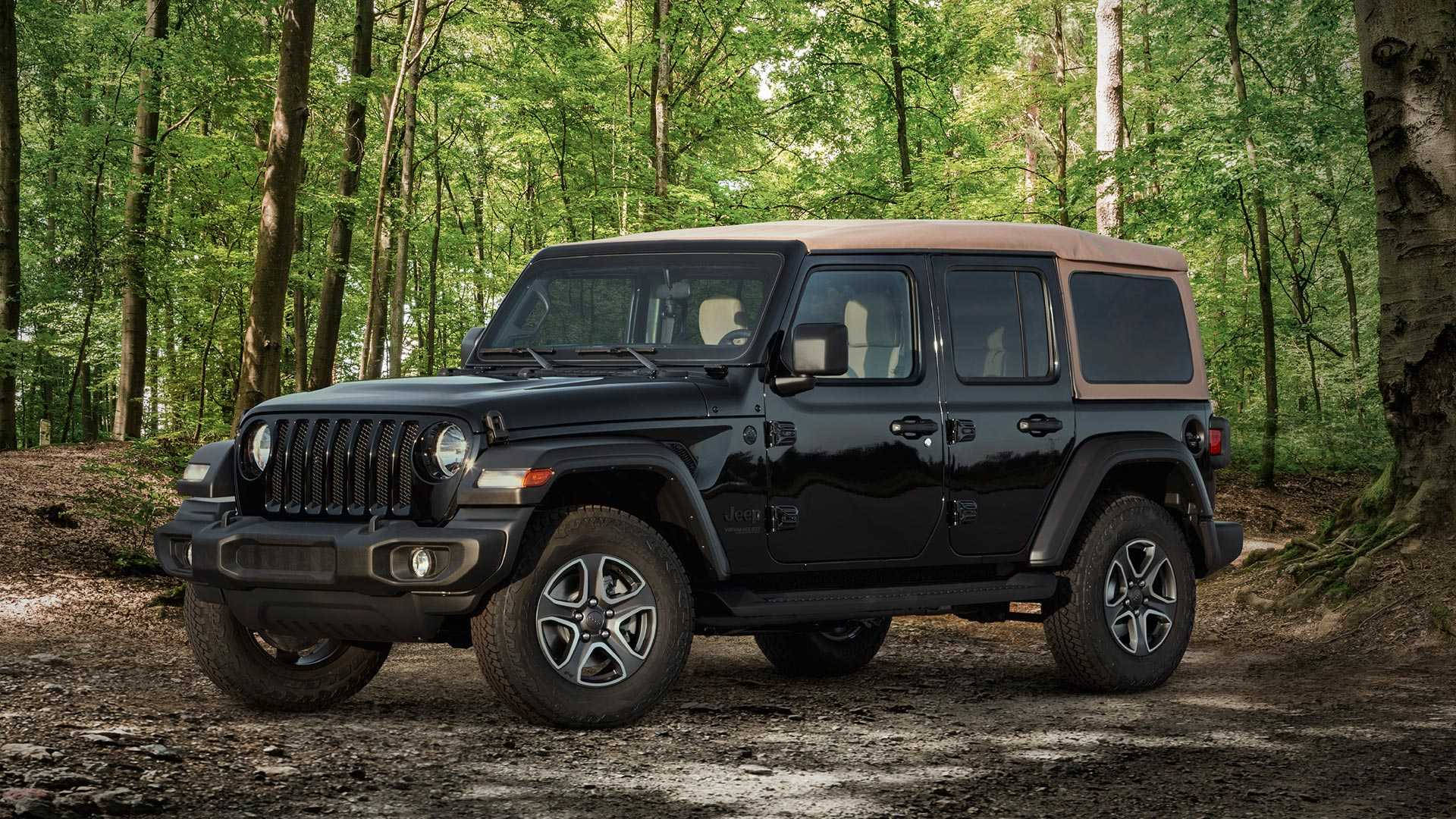 黑色Jeep Wrangler配備棕褐色軟頂停放在森林中。