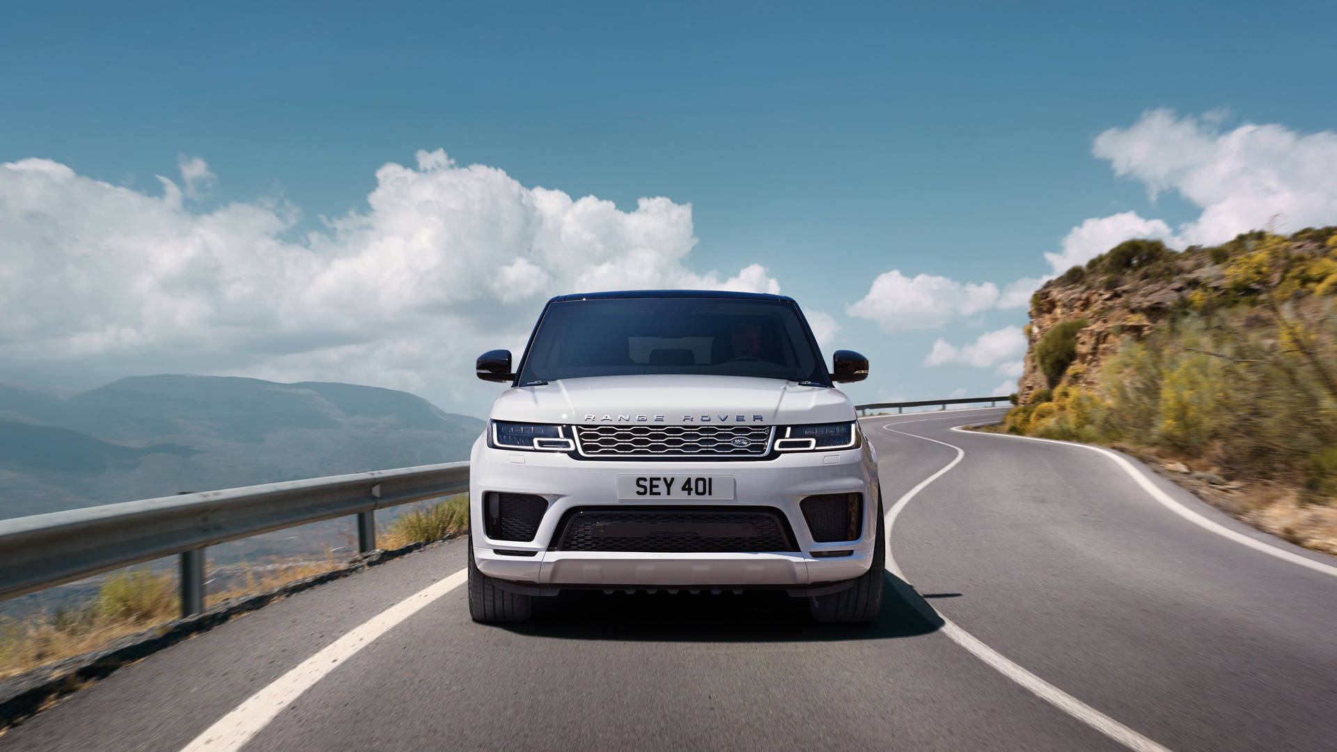 白色Range Rover Sport在山路上，風景如畫。