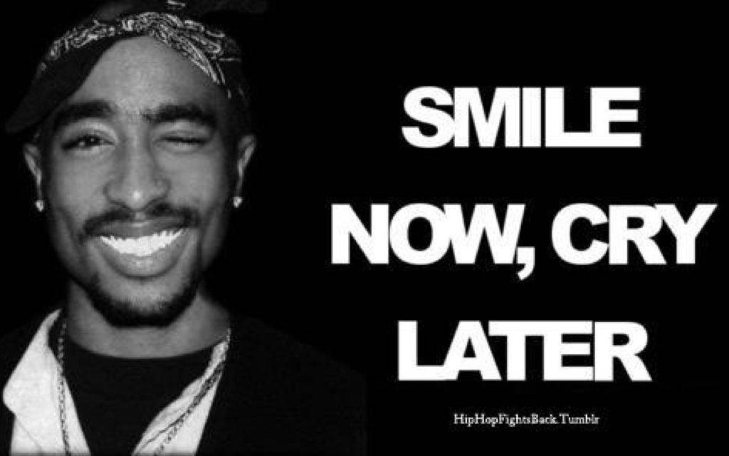 堅韌饒舌歌手 - 2Pac的鼓舞人心微笑 壁紙 — 一幅Tupac Shakur微笑的黑白肖像，上面有粗體文字寫著smile now cry later。