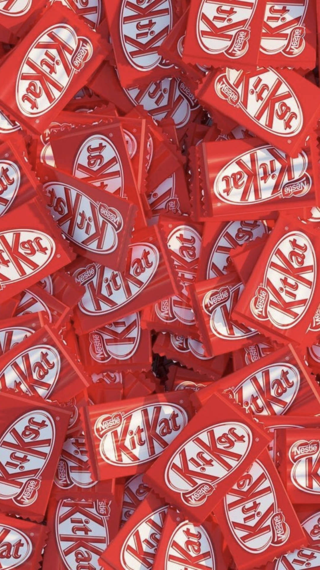 堆疊的 KitKat 巧克力 壁紙 — 無數紅色KitKat朱古力棒堆疊在一起，形成一個混亂而甜蜜誘人的特寫。