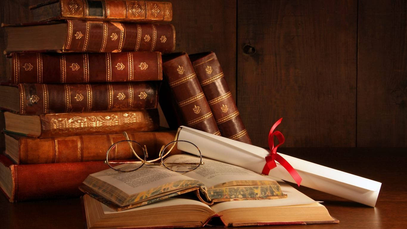 書籍 桌布 壁紙 — 堆疊的復古皮革裝訂書籍和一本打開的書本連同老花眼鏡放在木質表面上，旁邊是一個用紅絲帶綁著的文憑。