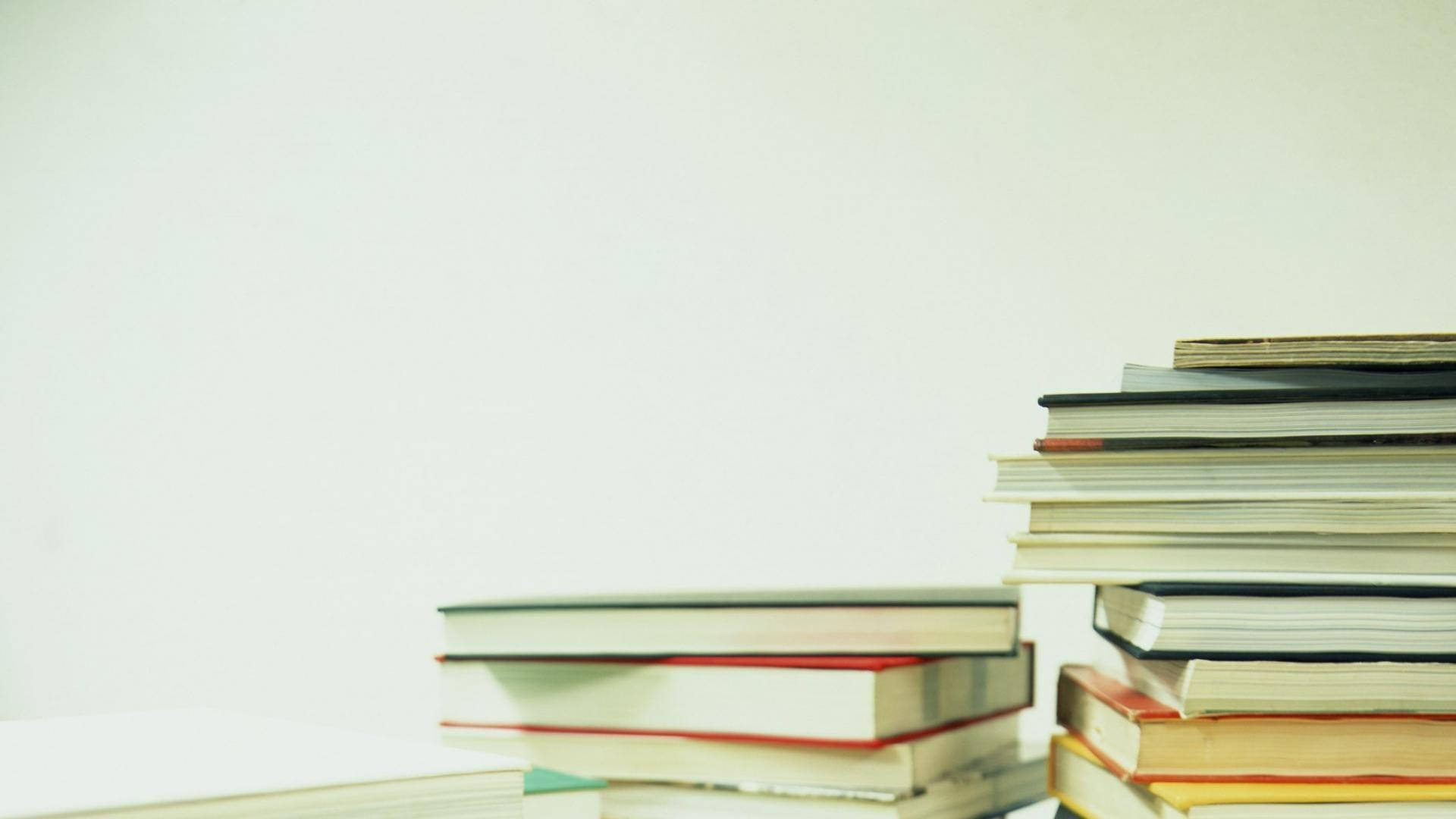 白色表面上色彩繽紛的書脊高書堆。