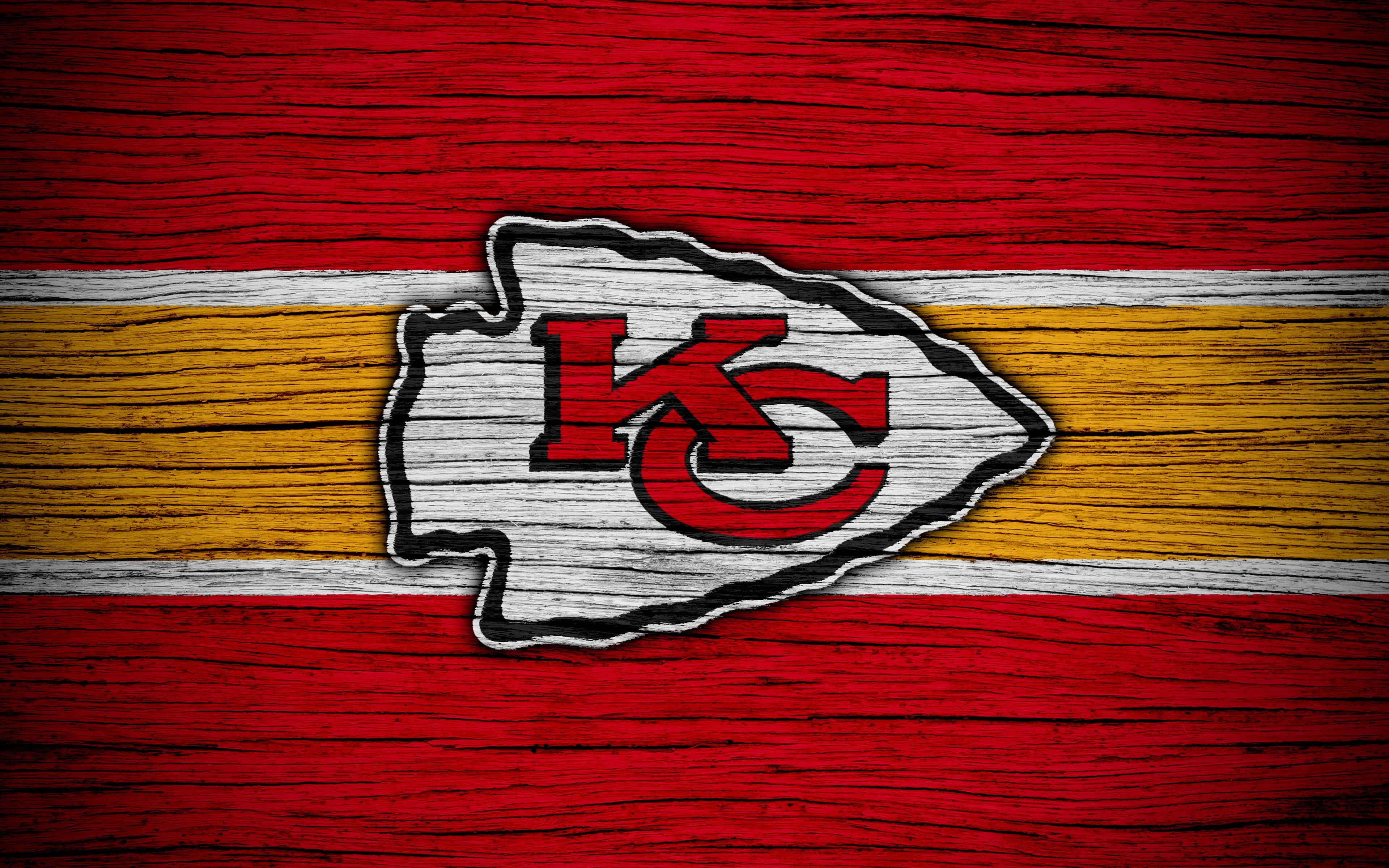 Kansas City Chiefs 桌布 壁紙 — 堪薩斯城酋長隊標誌在風化木板上，帶有紅、黃、白條紋。