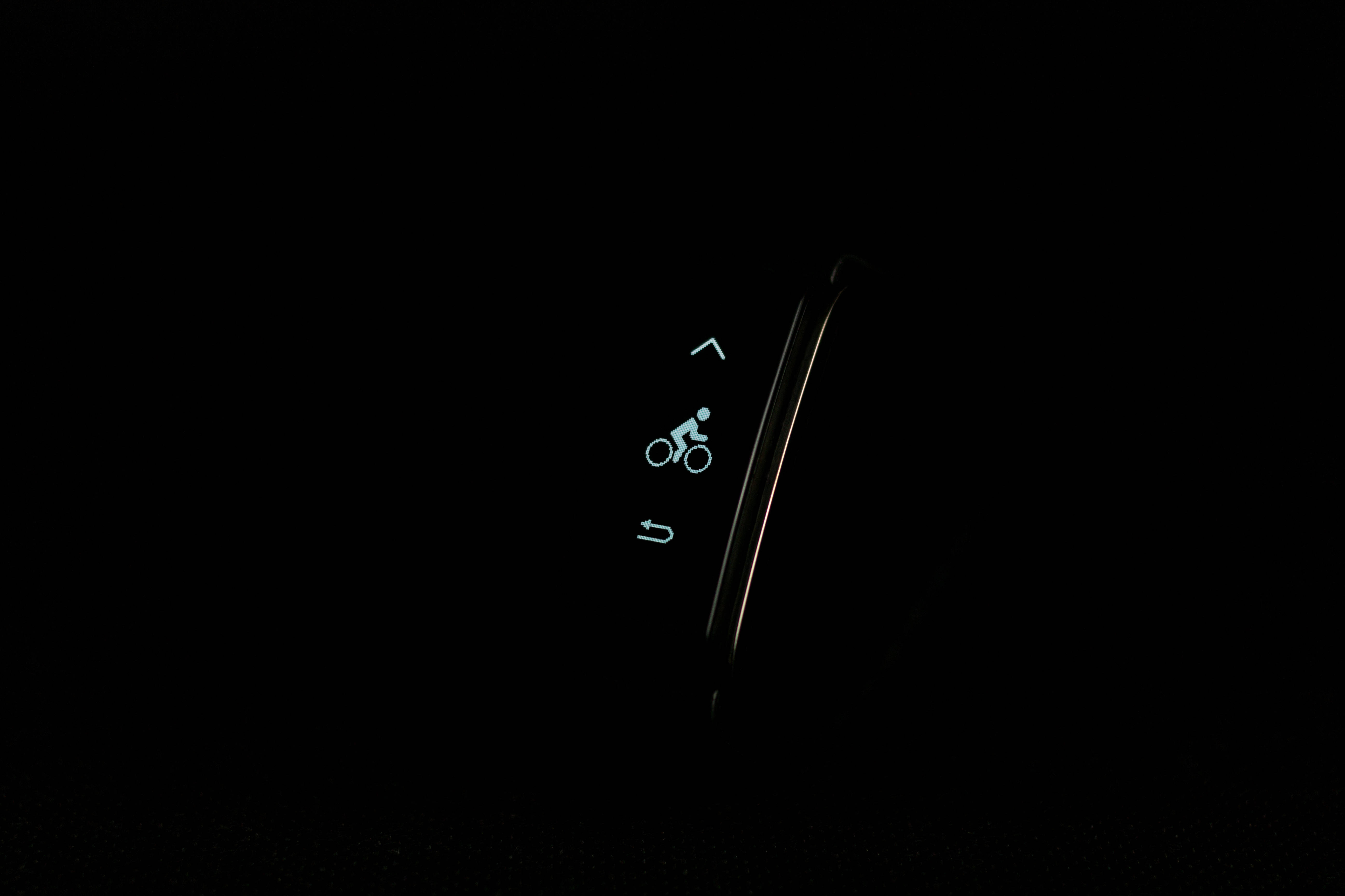場地自行車專用健身智能手錶 壁紙 — 在彎曲的智能手錶屏幕上，一個發光的藍色單車圖標，背景為純黑色。
