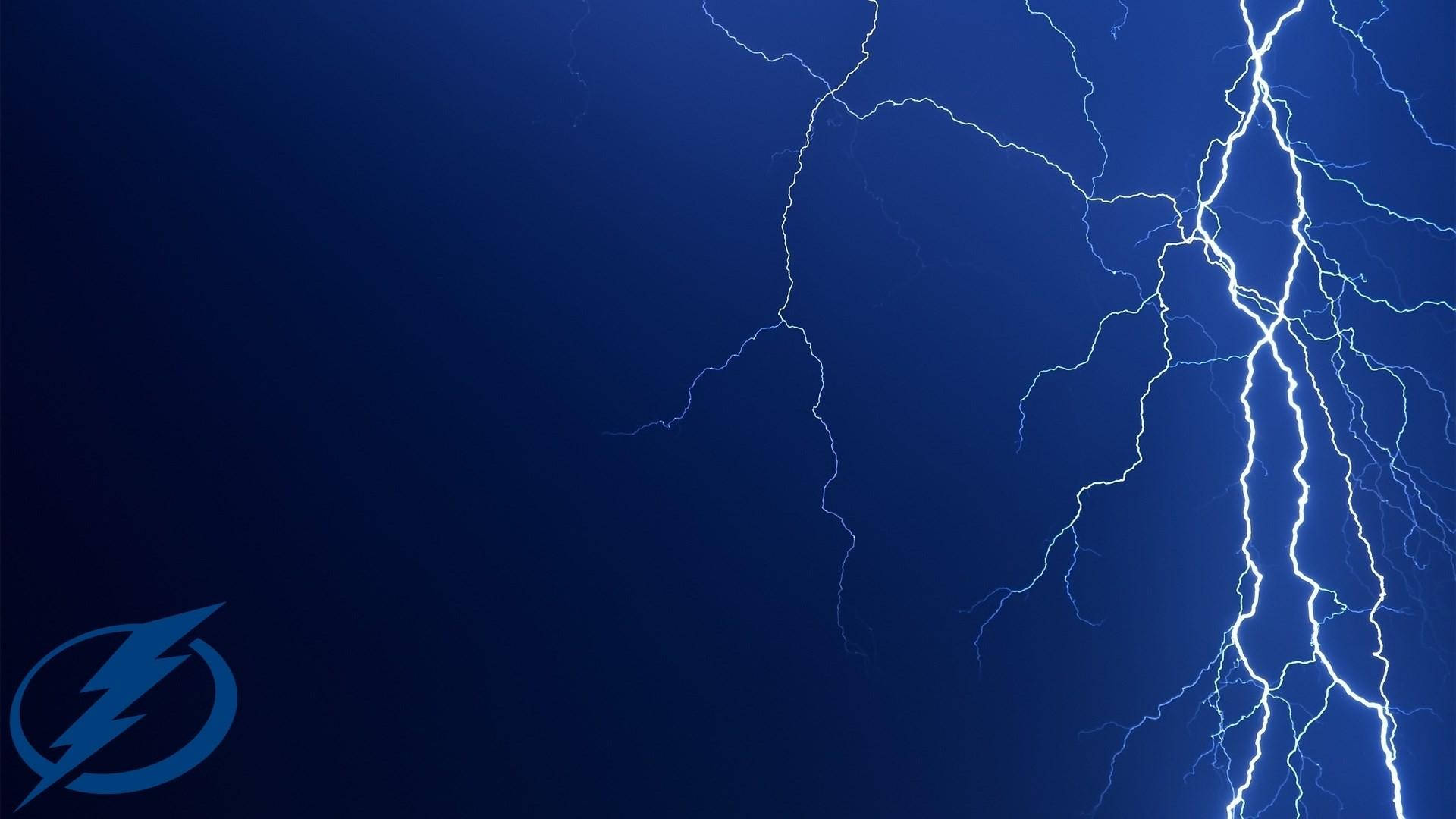 明亮的閃電照亮了深藍色的暴風雨天空，帶有閃電標誌。