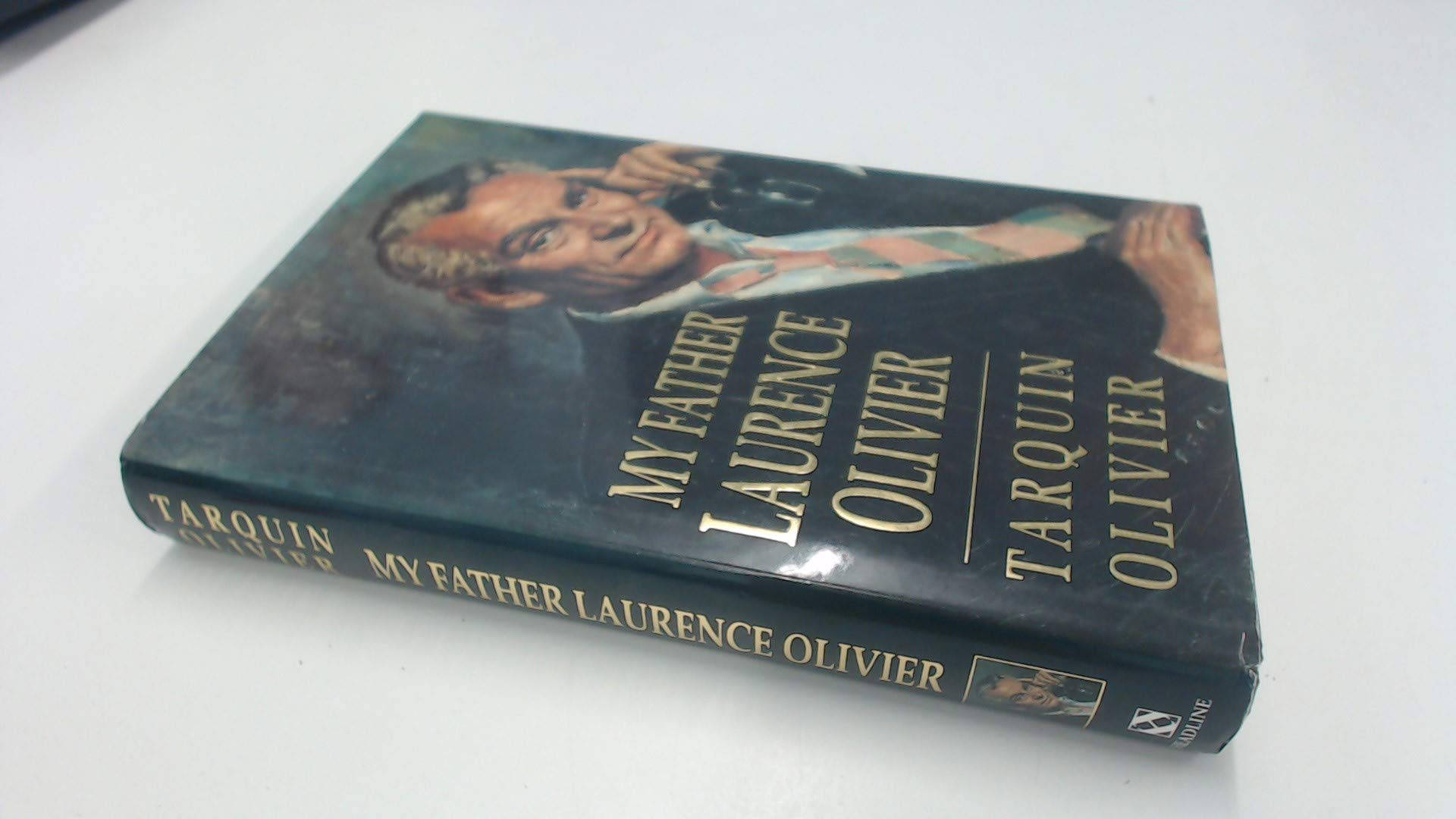 塔昆·奧利維爾所著《我的父親勞倫斯·奧利維爾》 壁紙 — 一本名為《My Father Laurence Olivier》的復古書，封面有一位男士的肖像，傾斜地放在純白色表面上。