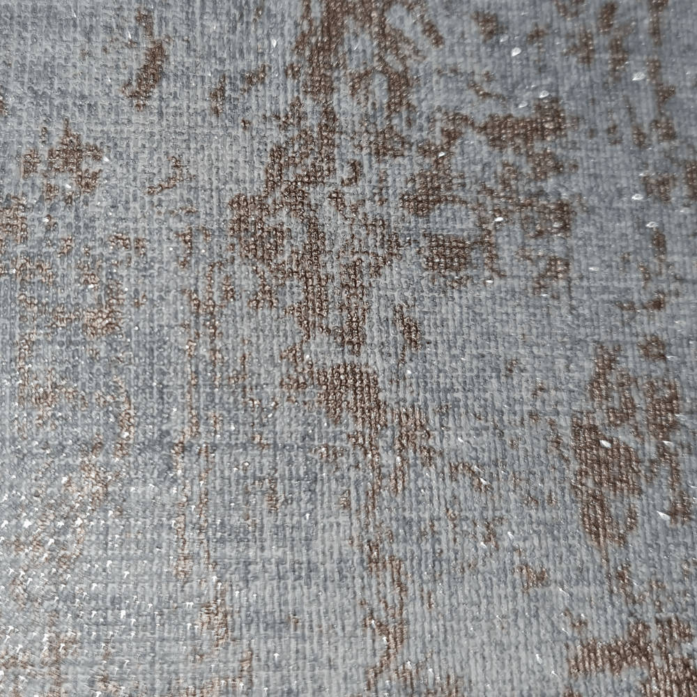 帶有棕色圖案和銀色閃粉紋理的灰色布料。