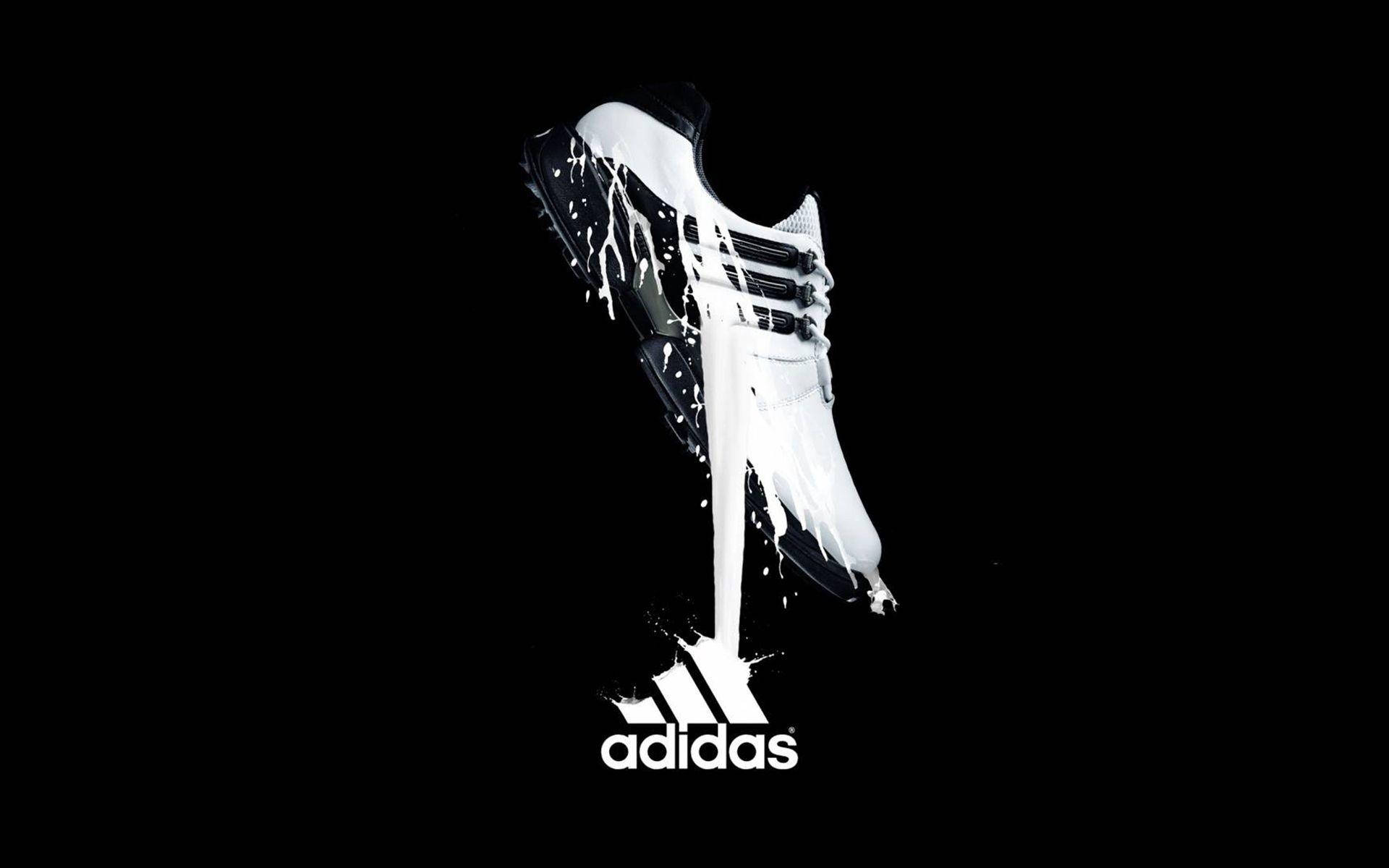 白色adidas運動鞋在黑色背景上滴落顏料。