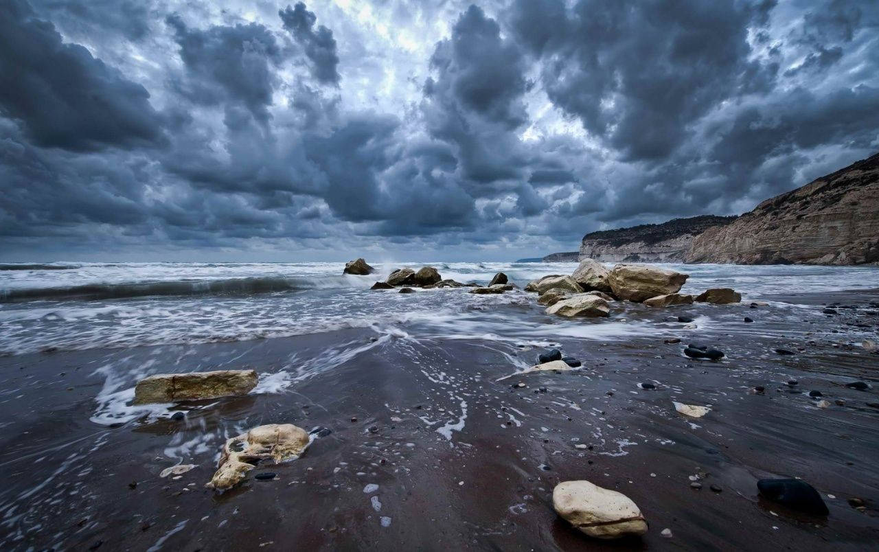 塞浦路斯多雲海洋 壁紙 — 黃昏時分，暴風雨的海浪拍打著陰暗潮濕的岩石，天空灰濛濛的。