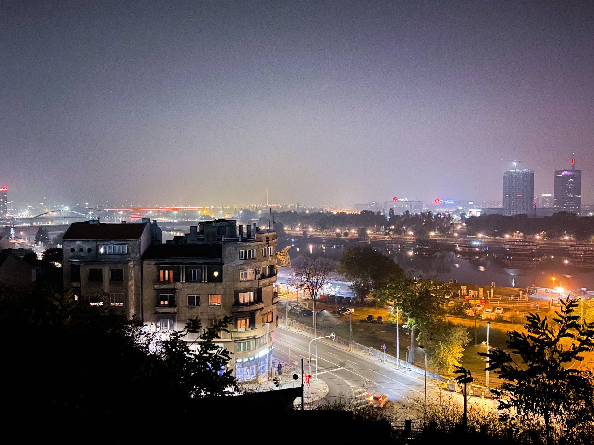 城市夜景，有燈光璀璨的建築物和一條河流