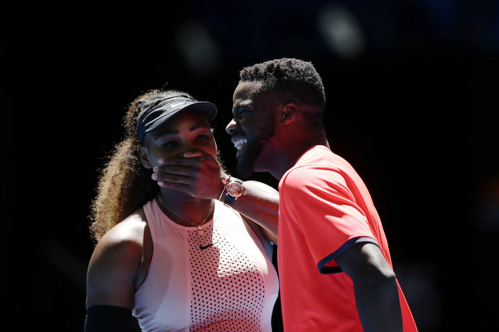 兩位微笑的網球手在比賽中分享一個頑皮的時刻。