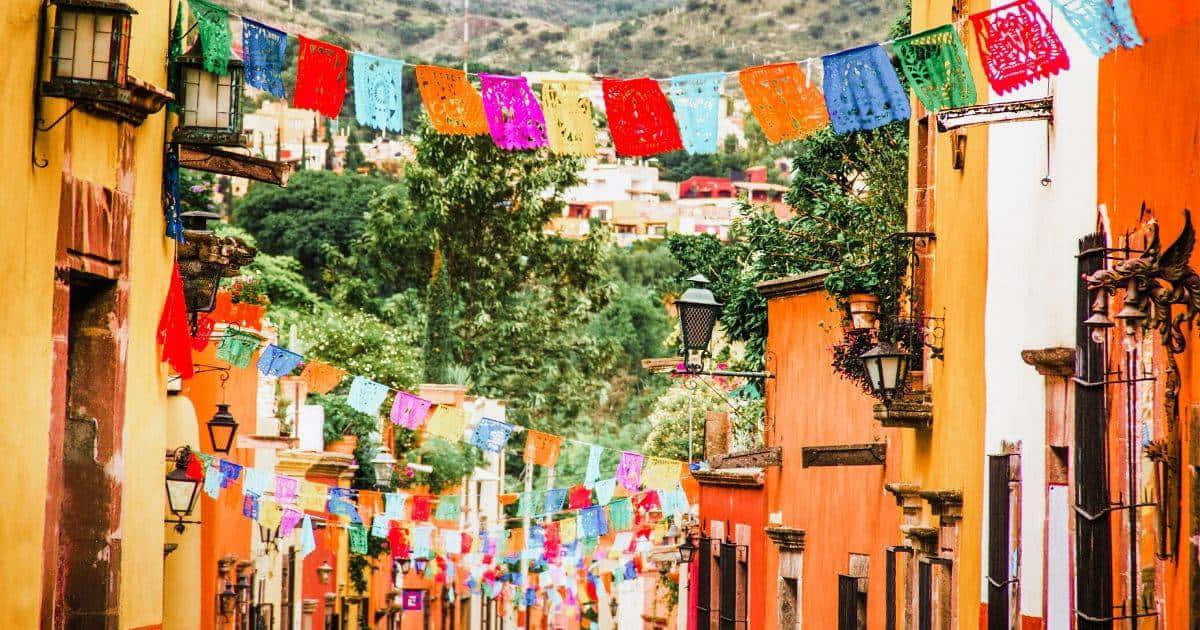 色彩繽紛的 papel picado 橫幅懸掛在節日街道的殖民建築之間。