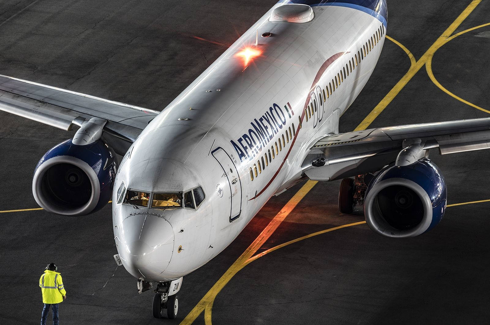 夜間停機坪上的 Aeromexico 飛機及地勤人員。