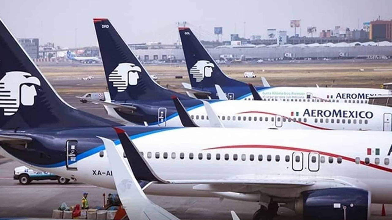 墨西哥航空飛機停泊在機場停機坪，附近有地面工作人員。