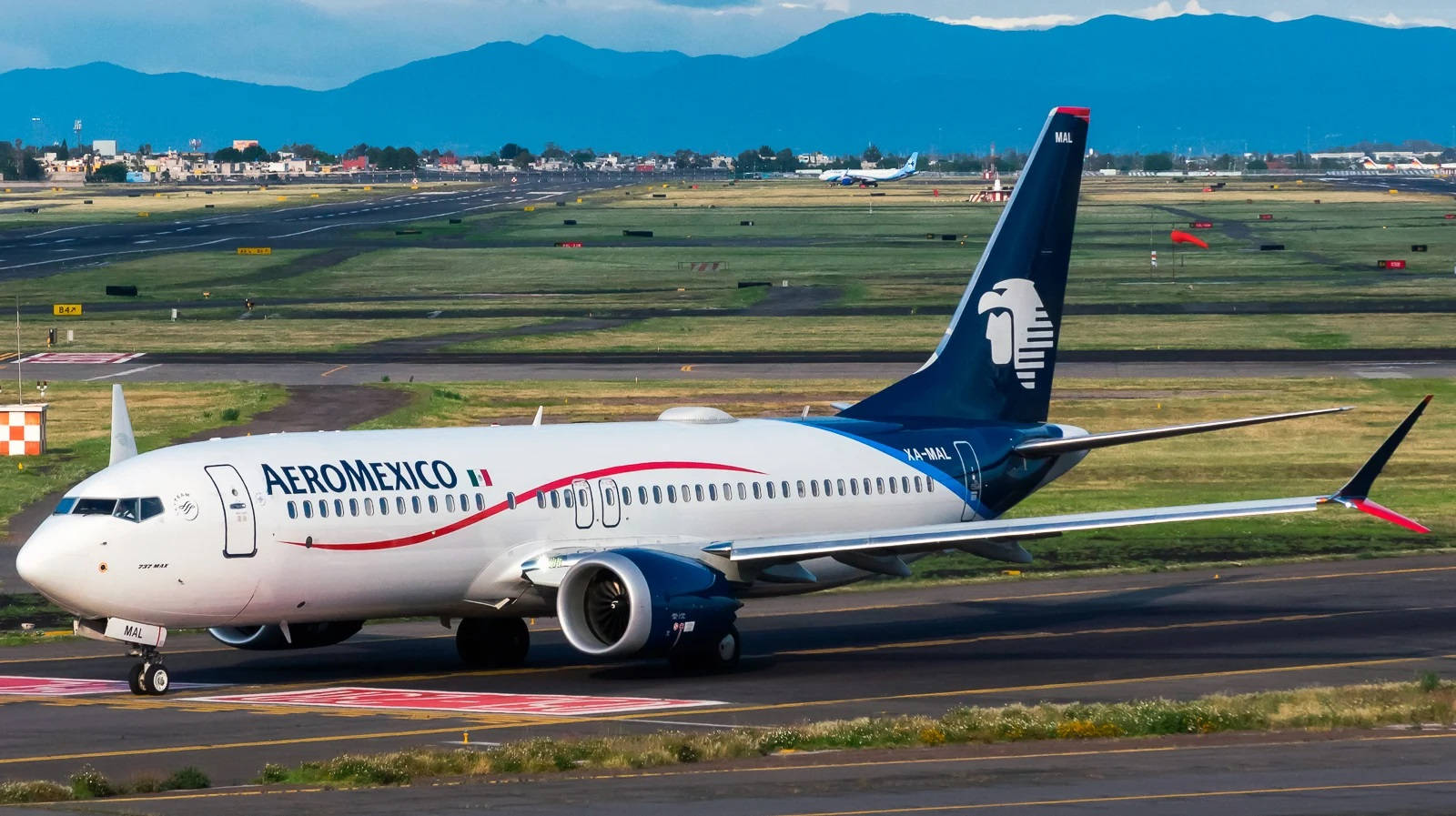 Aeromexico 飛機在跑道滑行，靠近山脈和城鎮。
