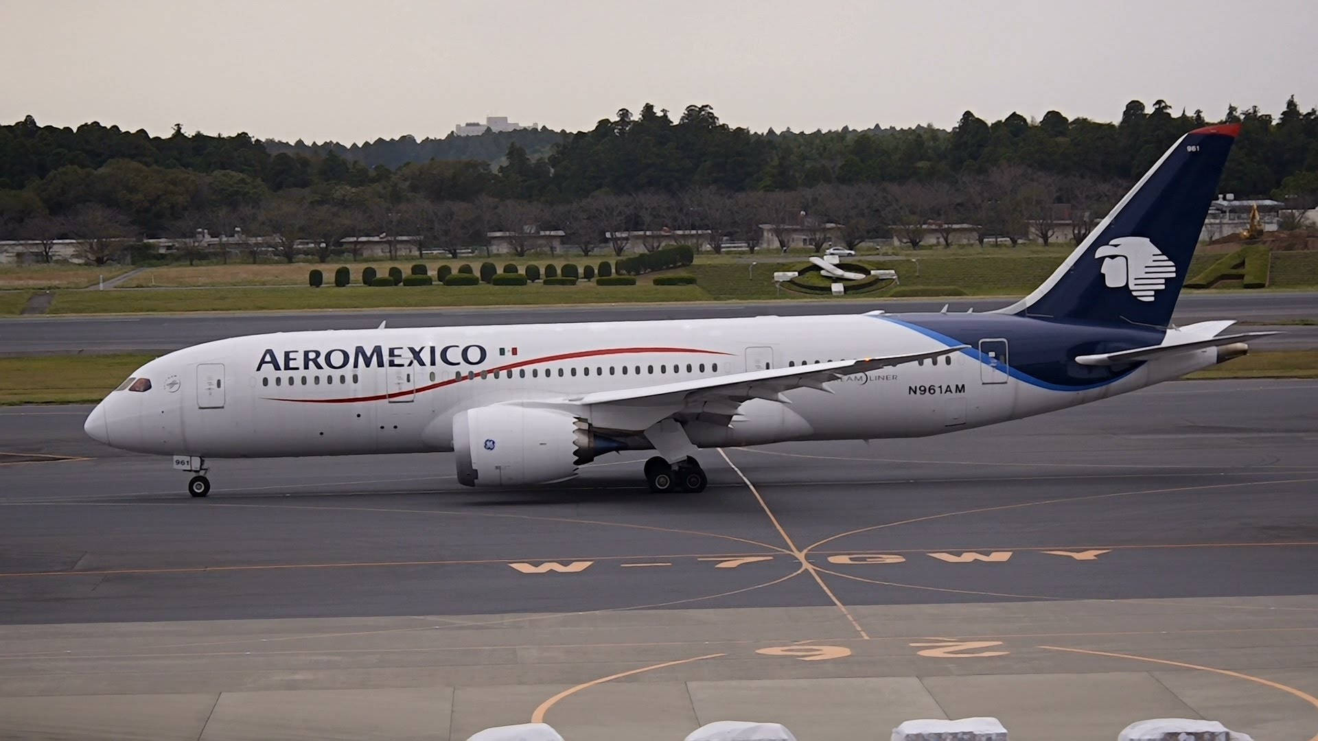 墨西哥航空飛機在機場停機坪上，背景有樹木