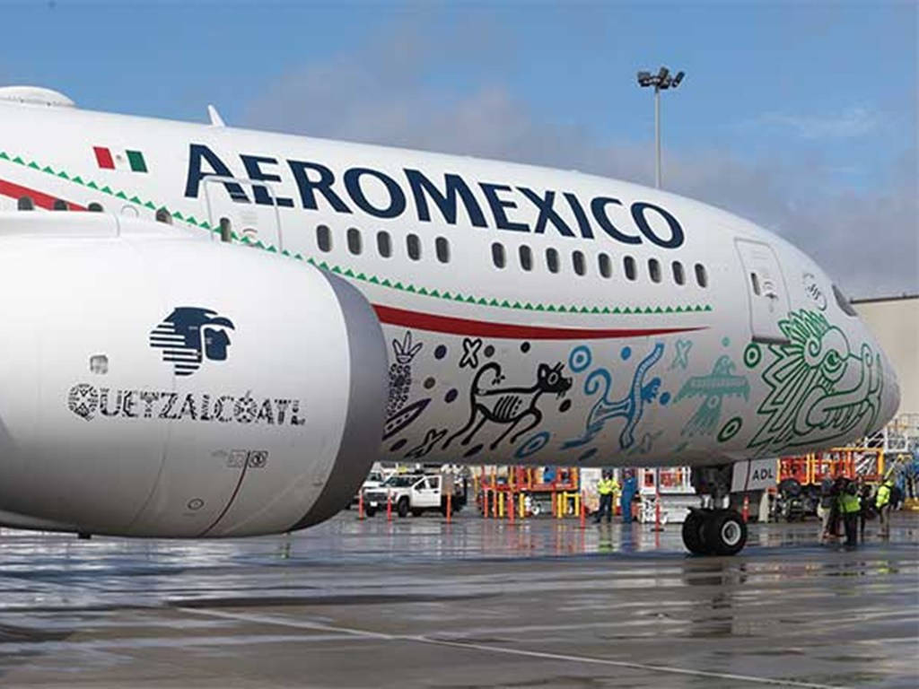 Aeromexico 飛機在潮濕的停機坪上，帶有 Guetzalcoatl 設計。