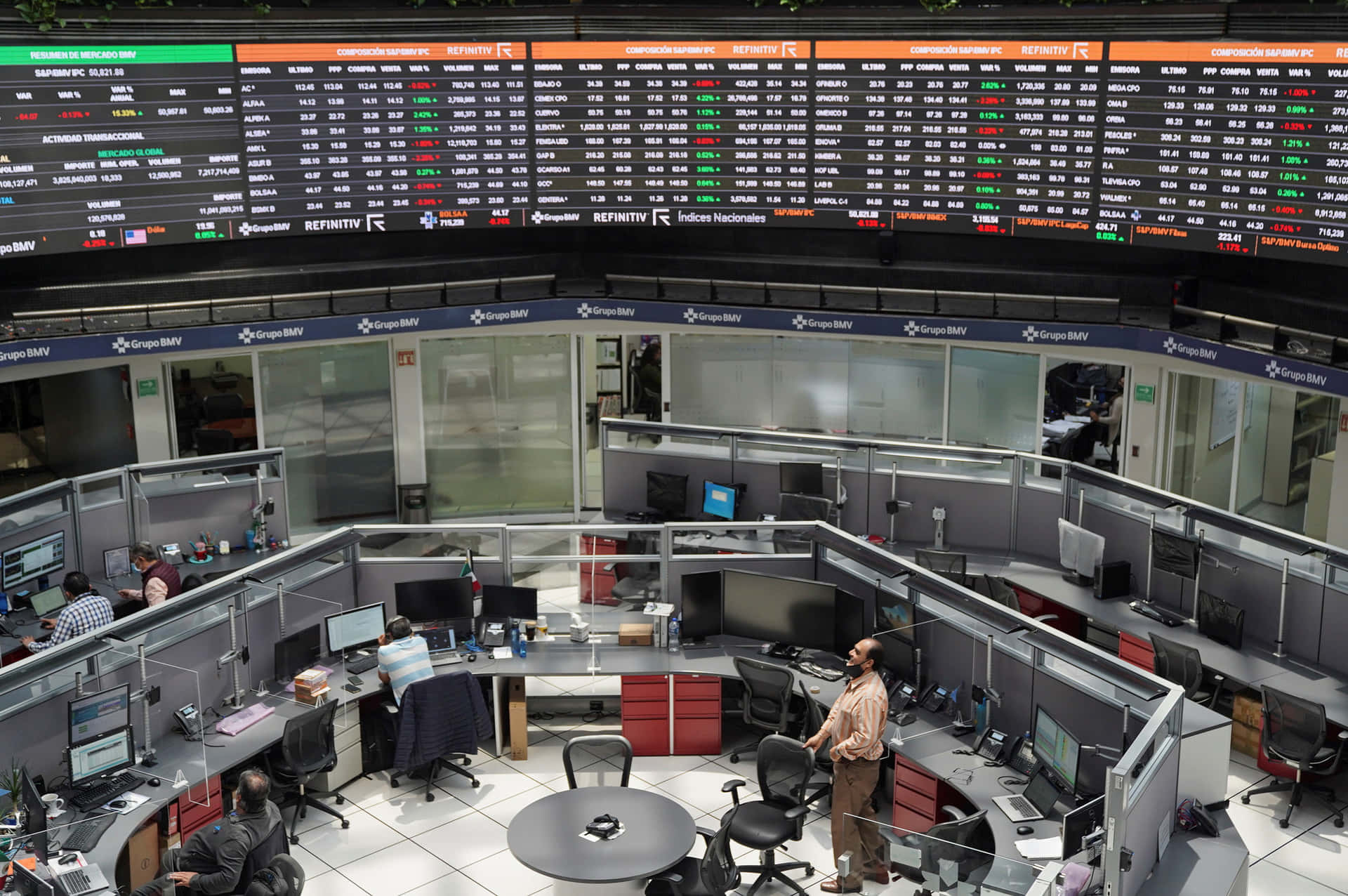 交易員在證券交易所的大型金融數據屏幕下工作。