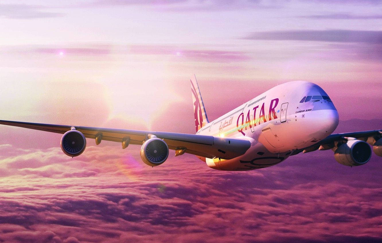 卡塔爾航空飛機在日落時分飛越色彩繽紛的雲層。