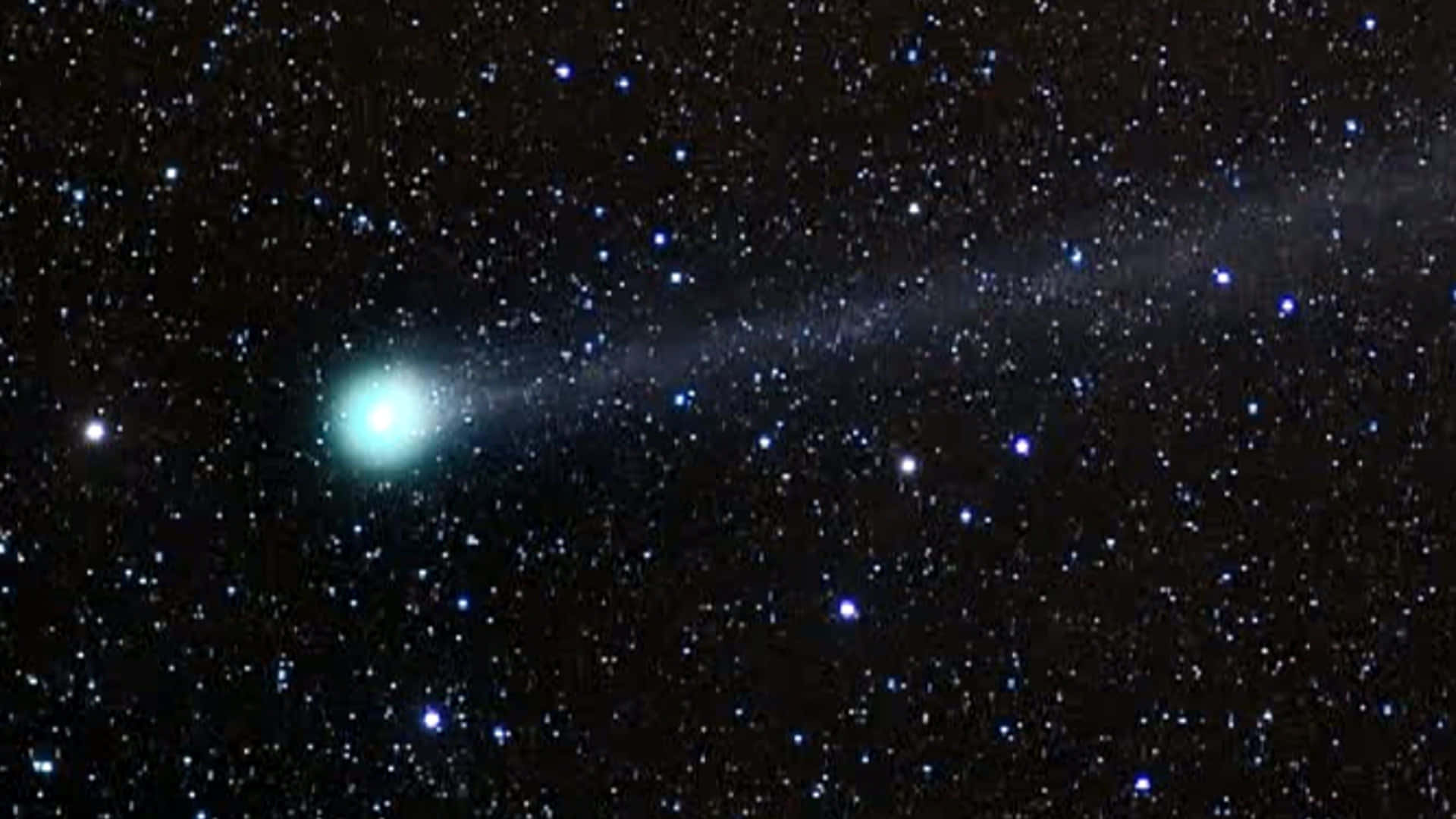 一顆彗星，在遙遠的星群中帶有發光的頭部和尾巴。