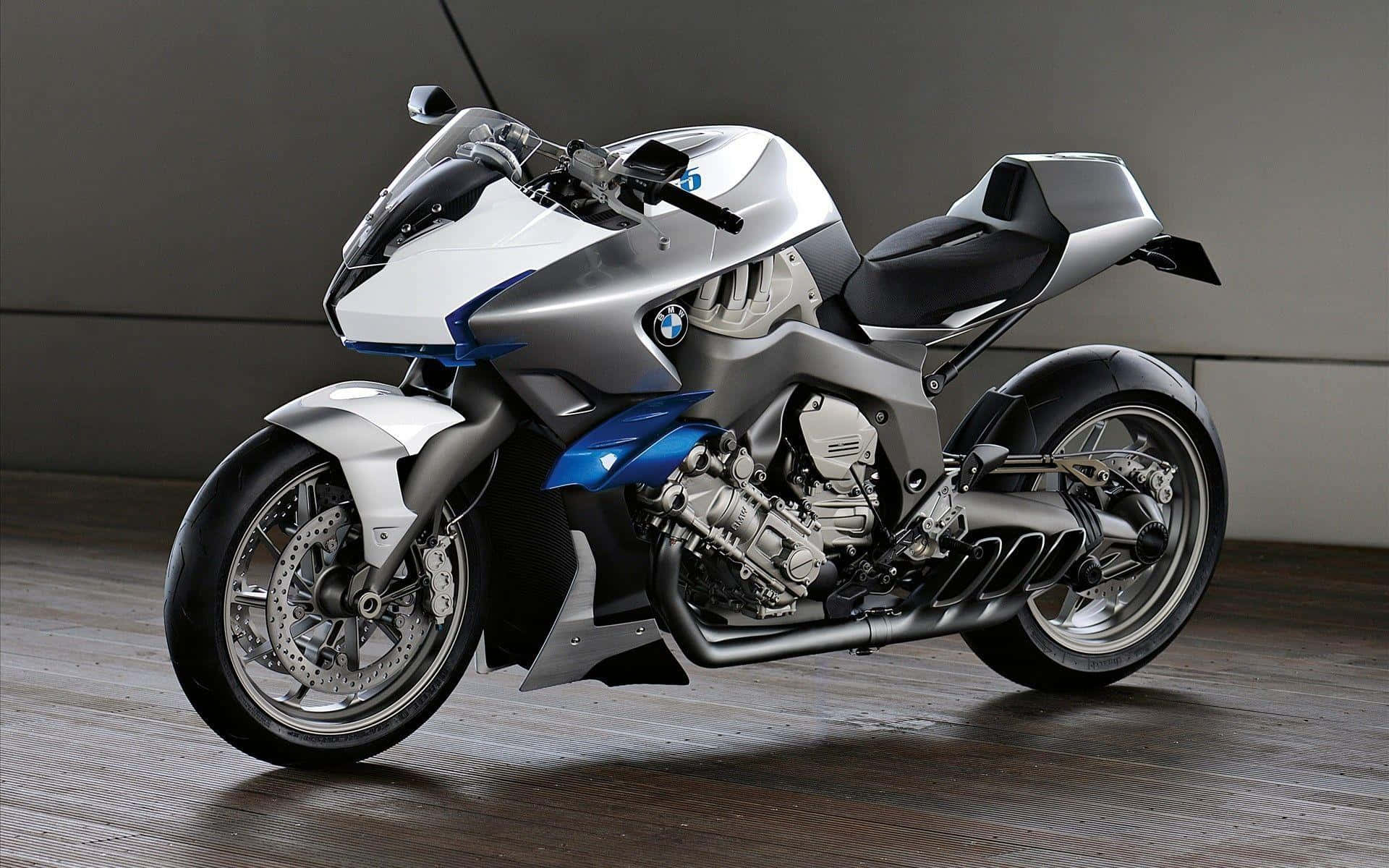 壯觀的BMW Motorrad機車背景 壁紙 — 一架流線型銀藍色BMW電單車，露出引擎細節，佇立在木地板上，背景係簡約灰色牆壁。
