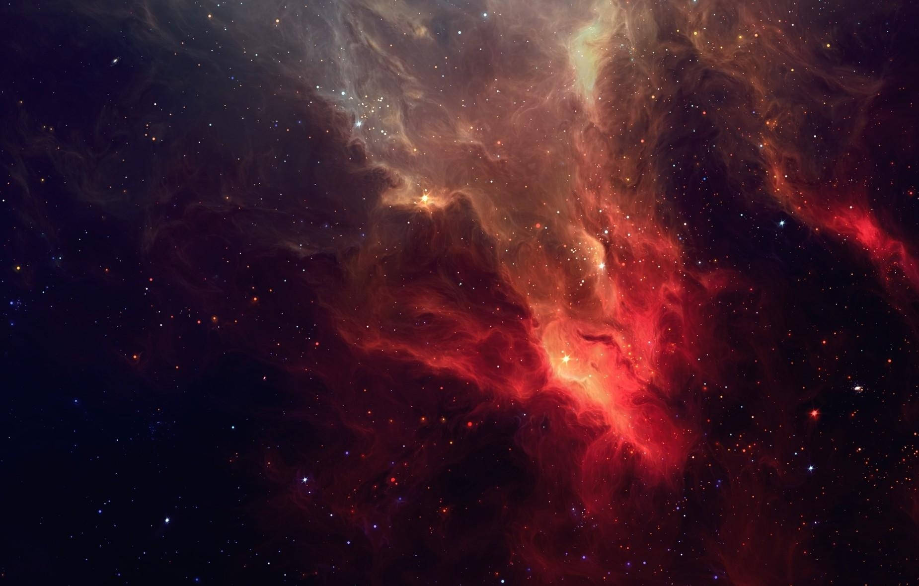 一個色彩繽紛的星雲，有紅色和橙色的雲朵以及散落的星星在深空中。