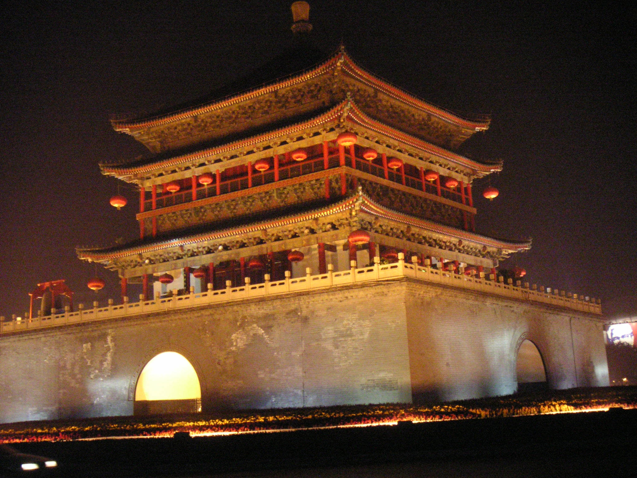 壯觀的西安鐘樓 壁紙 — 一座宏偉的傳統中式塔樓在夜晚被紅色燈籠和溫暖的金色燈光照亮，映襯著黑暗的天空。