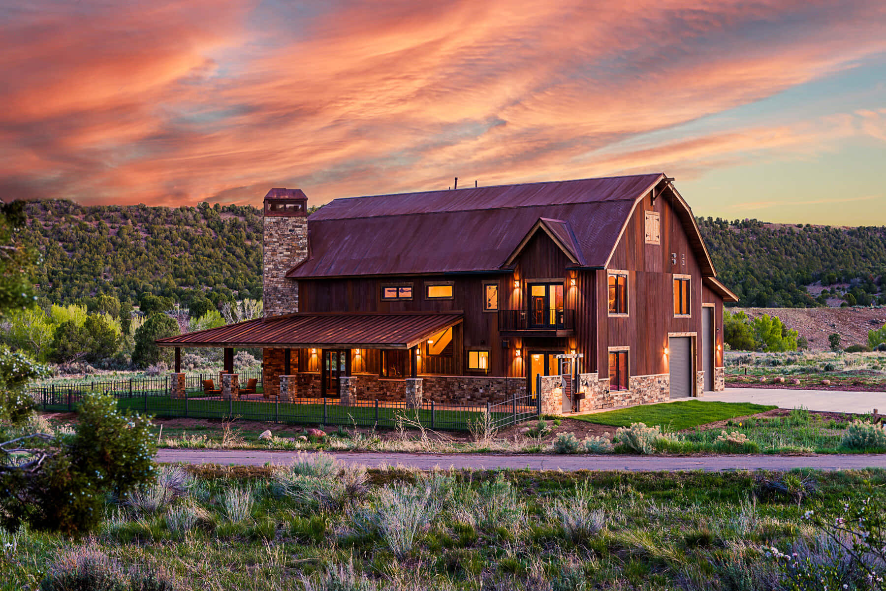 在山區景觀中，日落時分一間舒適的質樸房屋亮著溫暖的燈光。