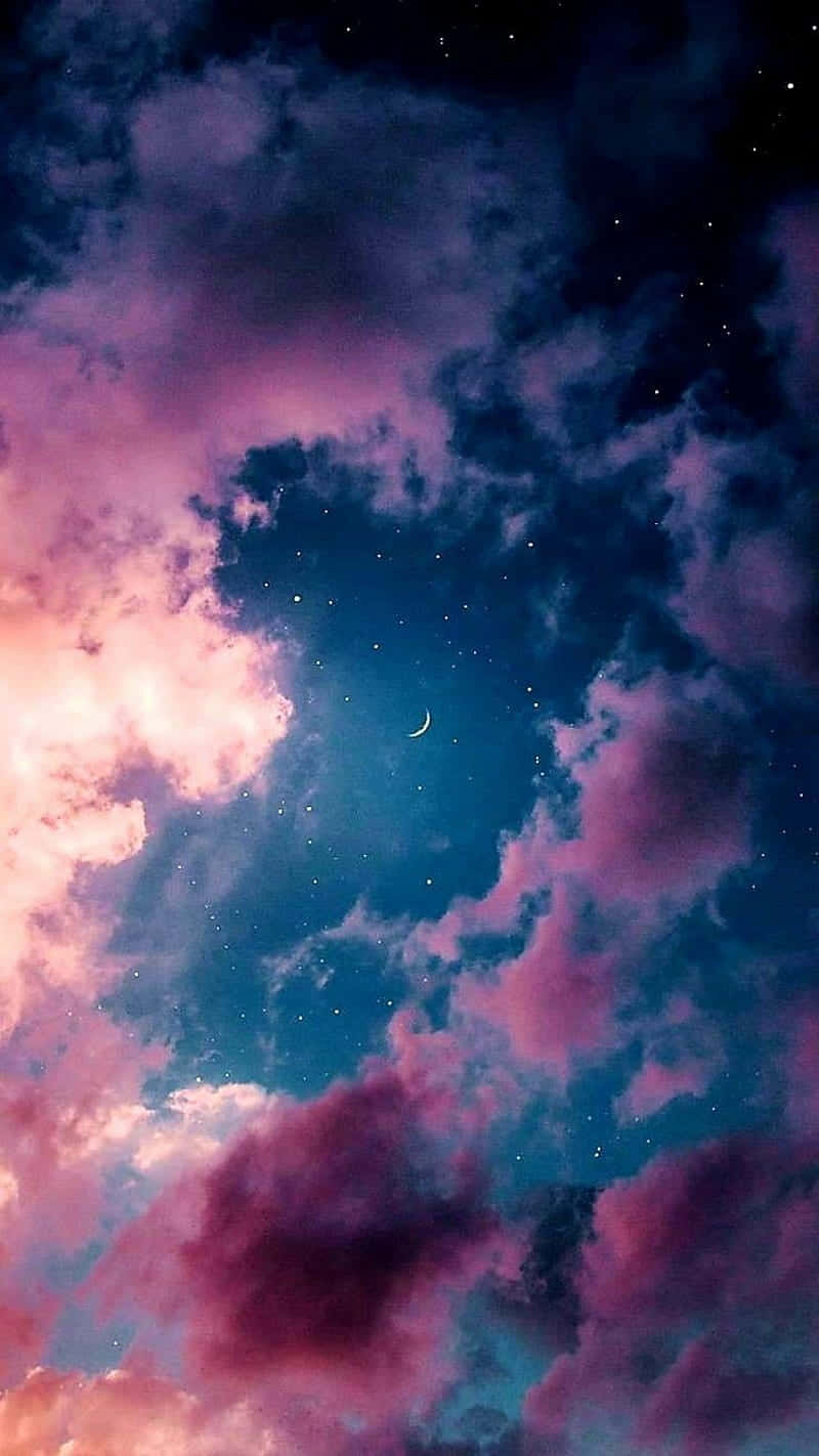 粉紅色同藍色嘅雲喺新月同星星下面，喺寧靜嘅夜空飄浮。