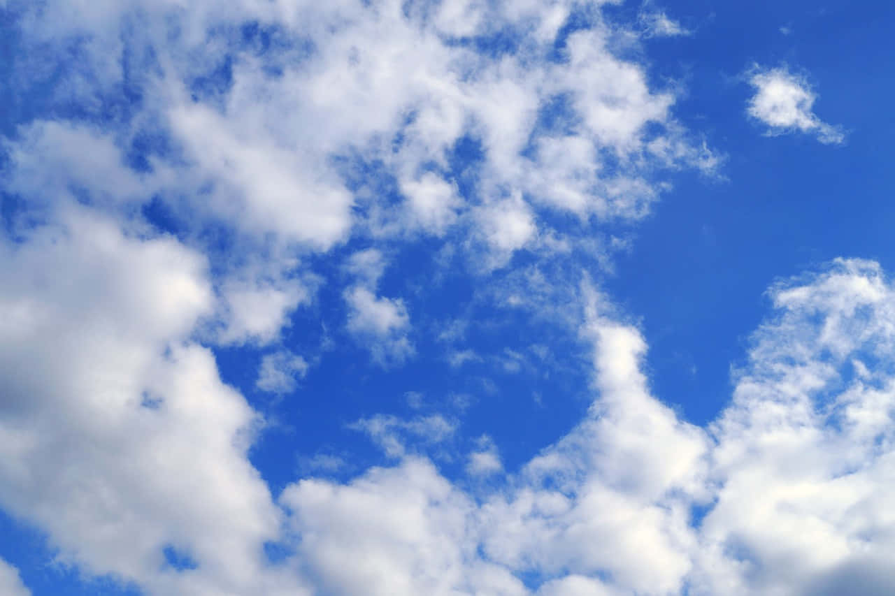 壯麗天際線：雲海與山林交織 壁紙 — 充滿活力的藍天，蓬鬆的白雲在晴朗的白天大氣中飄移。