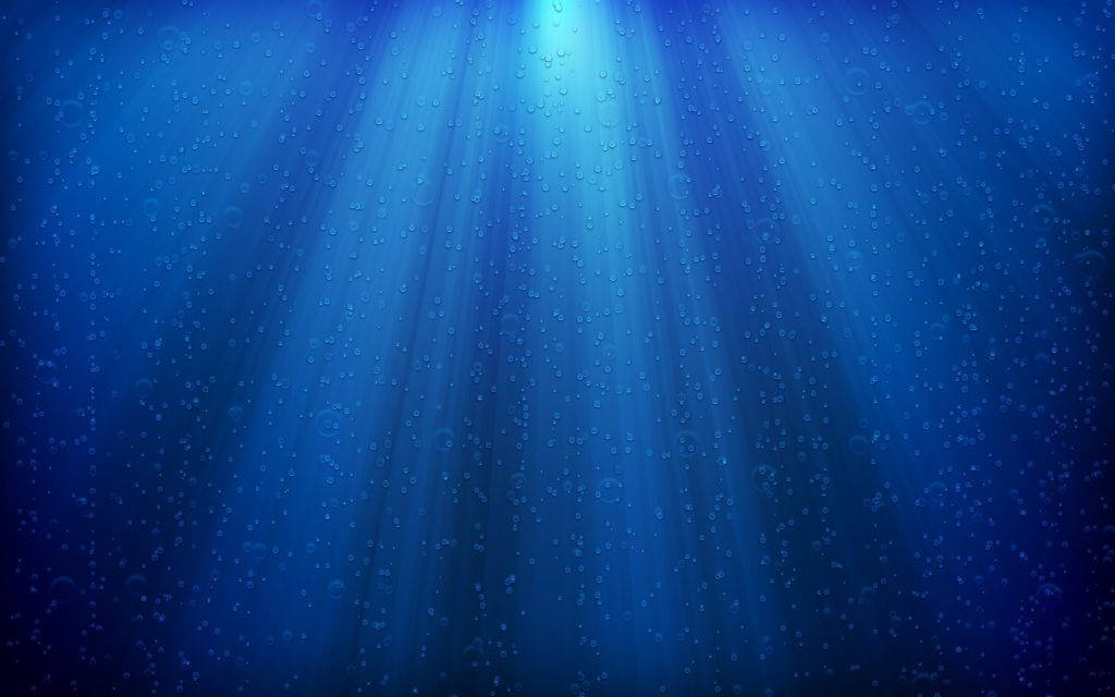 陽光穿過深藍色海水，帶有浮動氣泡。