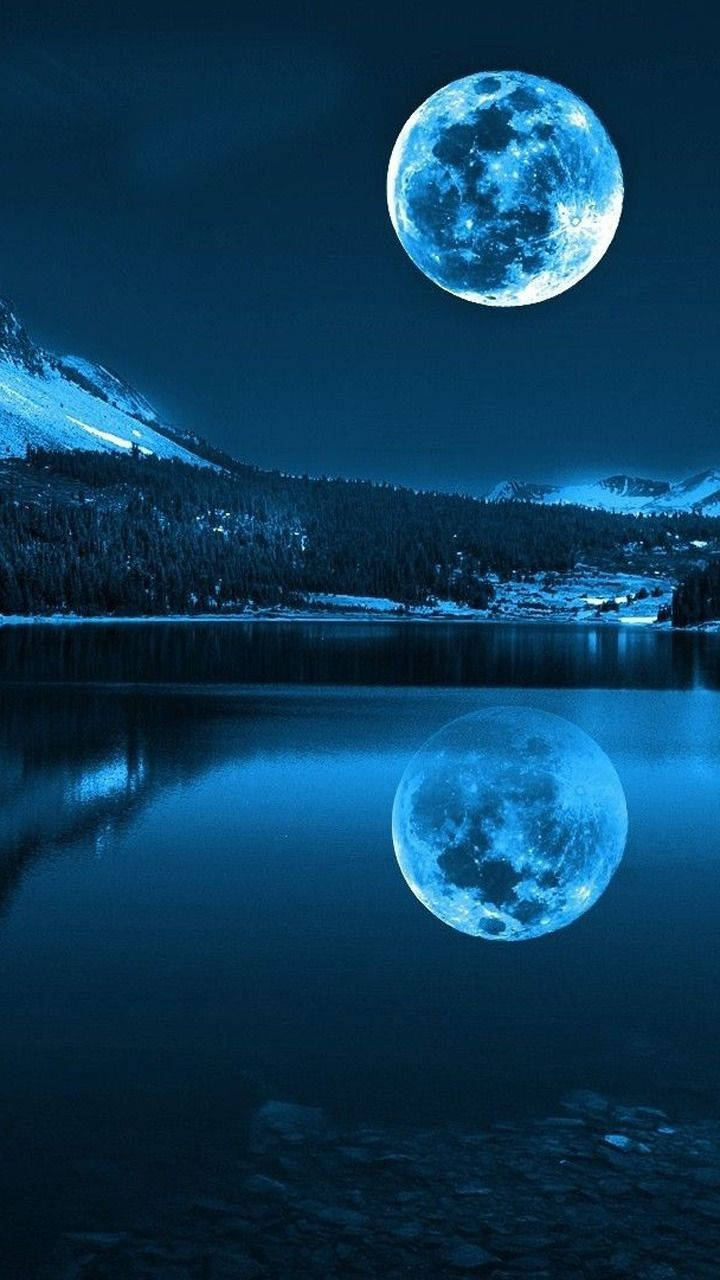藍月倒映在積雪的山湖中（夜晚）。