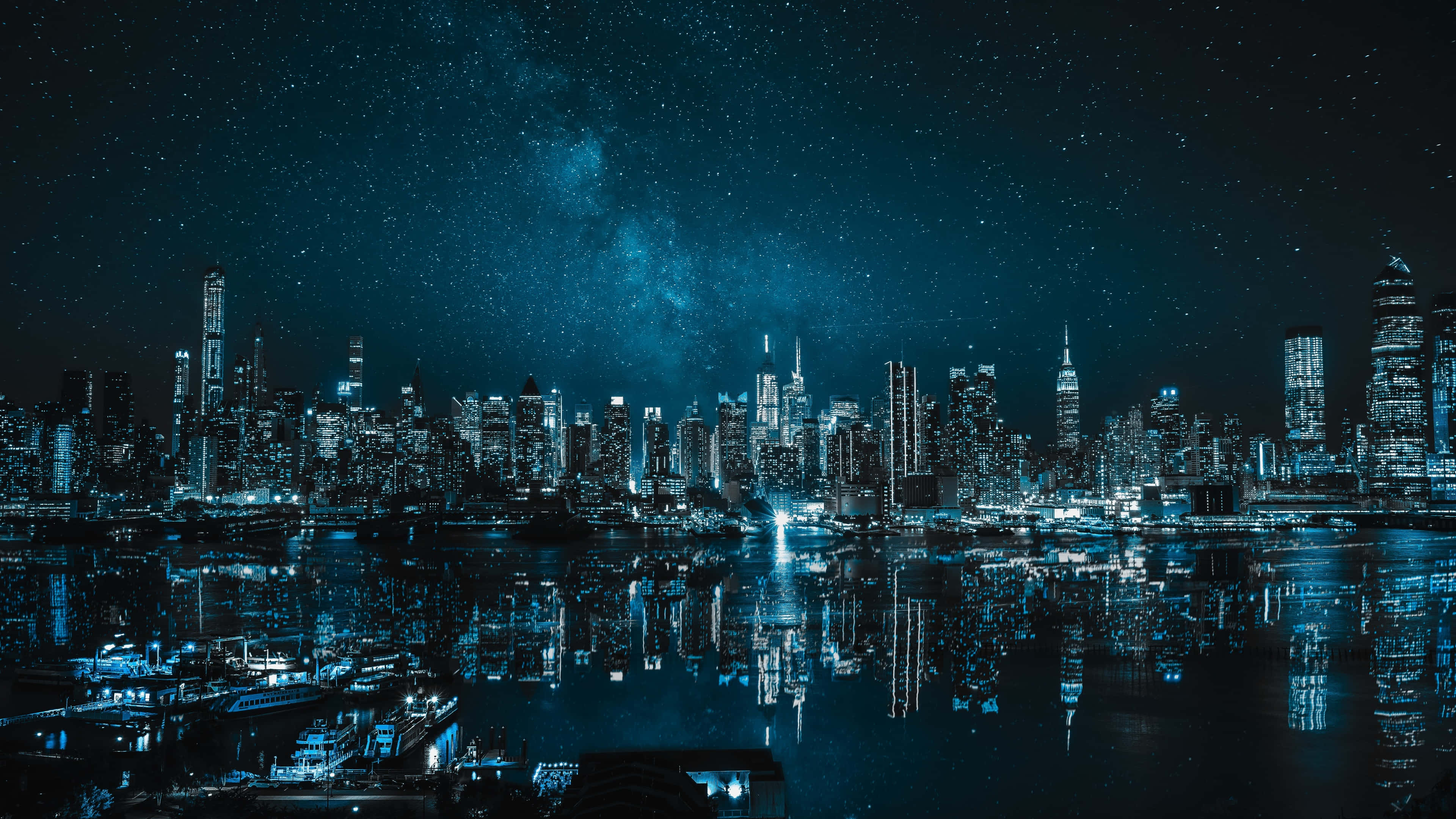 城市景觀 桌布 壁紙 — 壯麗的夜景城市景觀，摩天大樓在星空下倒映在水中，銀河清晰可見。