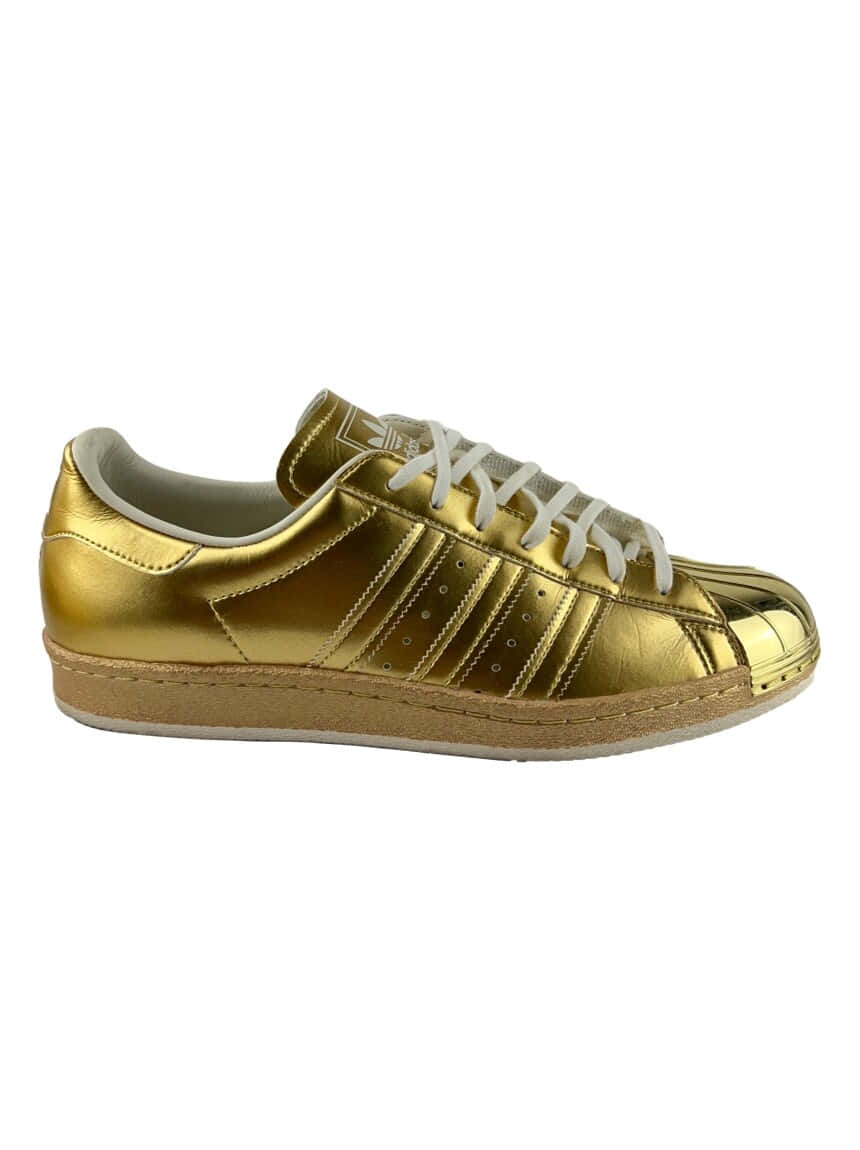 閃亮的金色Adidas Superstar運動鞋，配有白色鞋帶和橡膠鞋底。