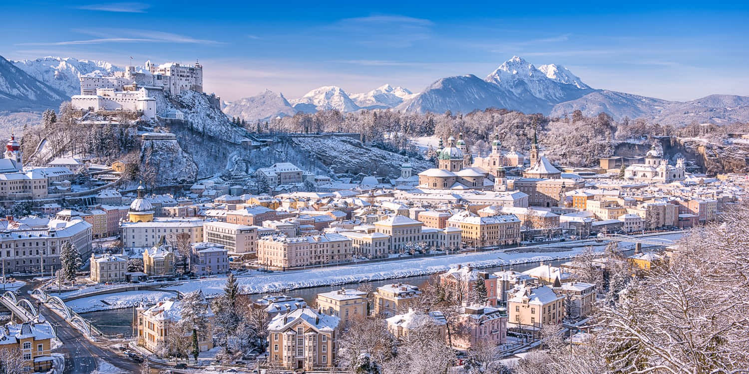 藍天下以山脈為背景的白雪覆蓋城市