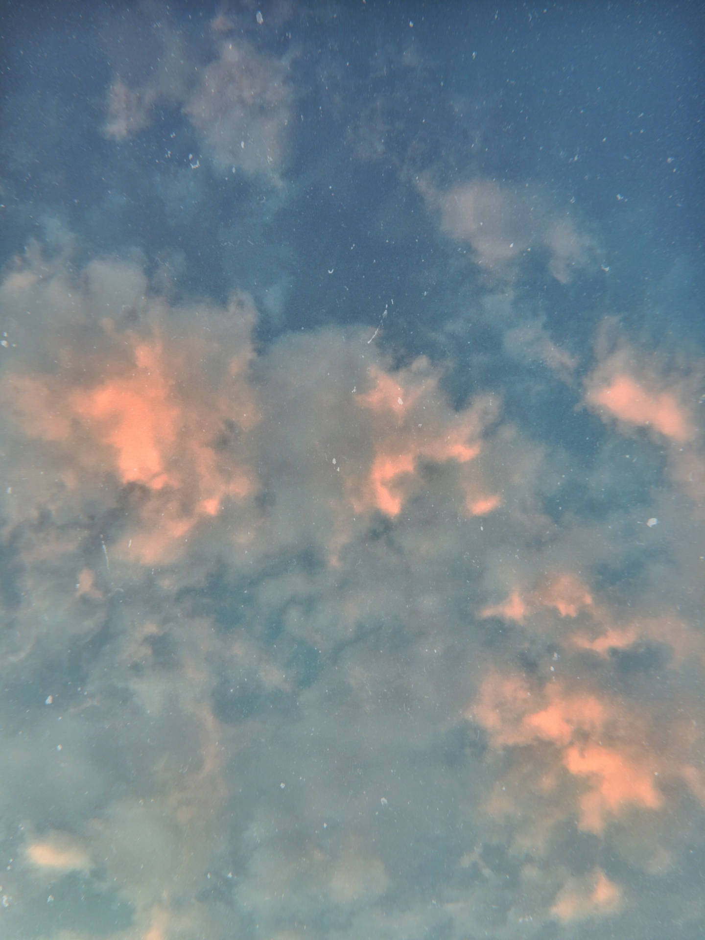 柔和嘅藍色同蜜桃色雲朵喺星空暮色中發光。