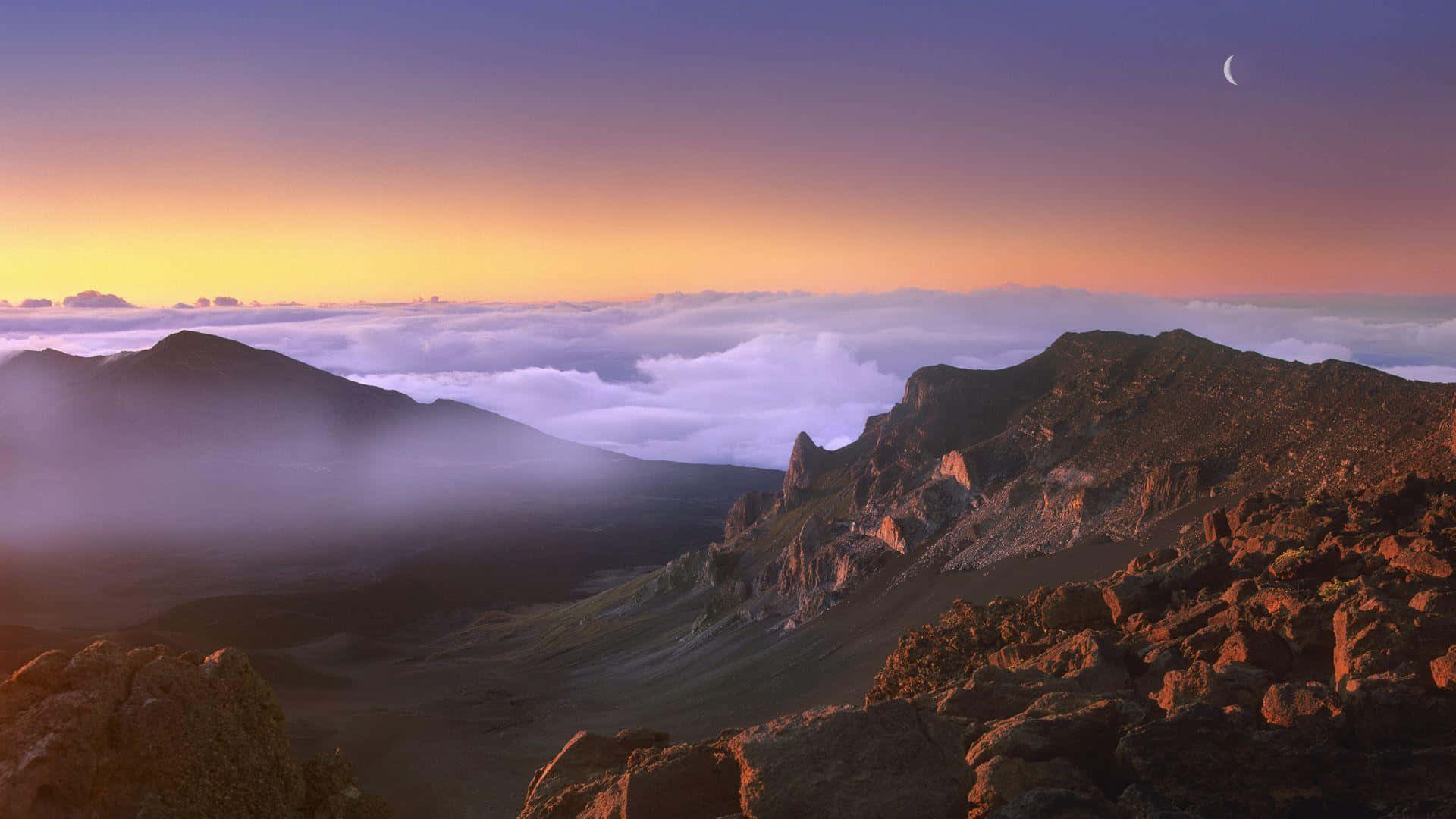 夏威夷火山國家公園哈雷阿卡拉山 壁紙 — 黎明時分，雄偉的山峰聳立於雲海之上，一彎新月懸掛在紫橙色的天空中。